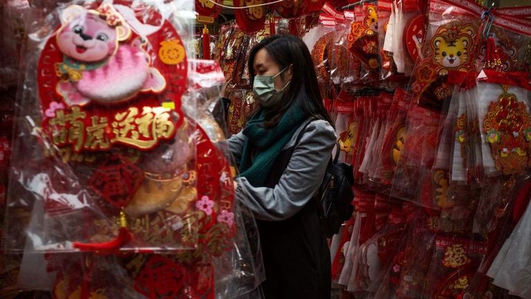 Женщина покупает новогодние украшения в Китае.