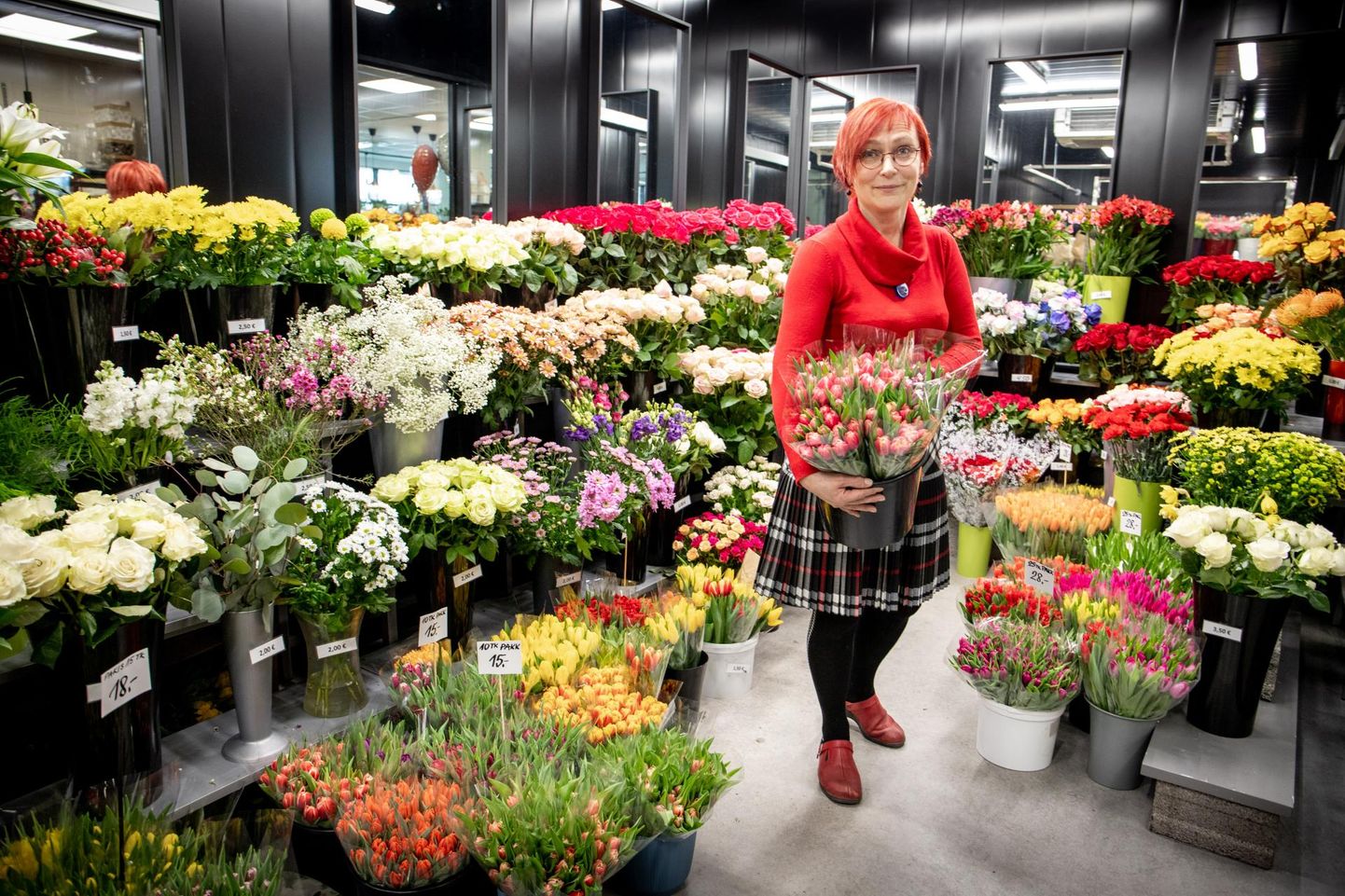 Tootsi lillepoe müüja Janne Põder näitab naistepäeva menukeid tulpe.