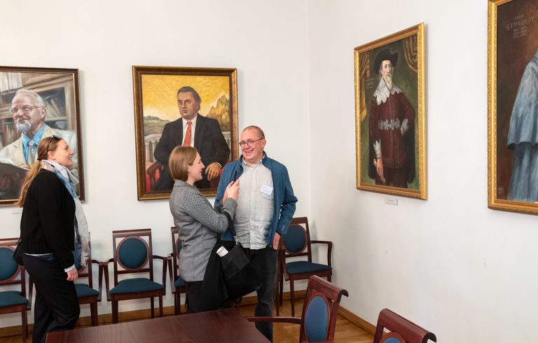 Külalised senati saalis, mille seintel rektorid ning otse pildistaja ees ülikooli kantsler Johan Skytte.
