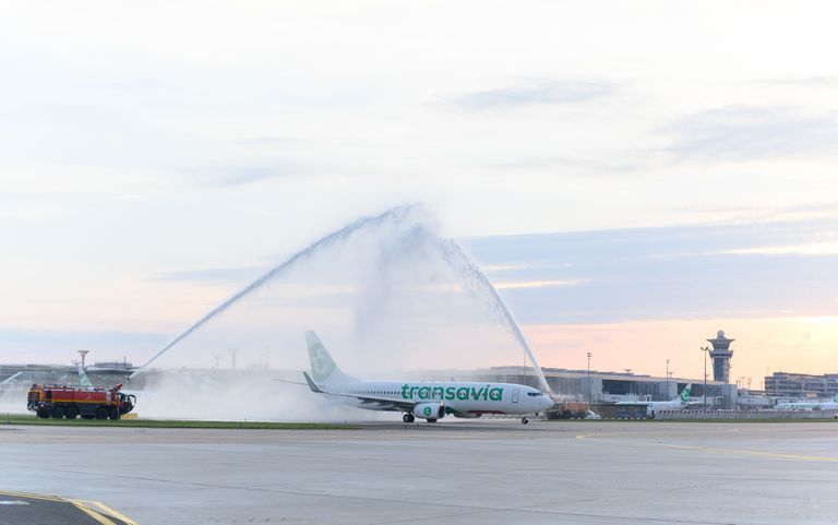 Пожарные приветствуют Boeing 737-800 Transavia в аэропорту Орли (Париж) водным салютом во время поездки по взлетно-посадочной полосе перед взлетом 26 июня 2020 года. Аэропорт на три месяца был закрыт для коммерческих полетов из-за пандемии.