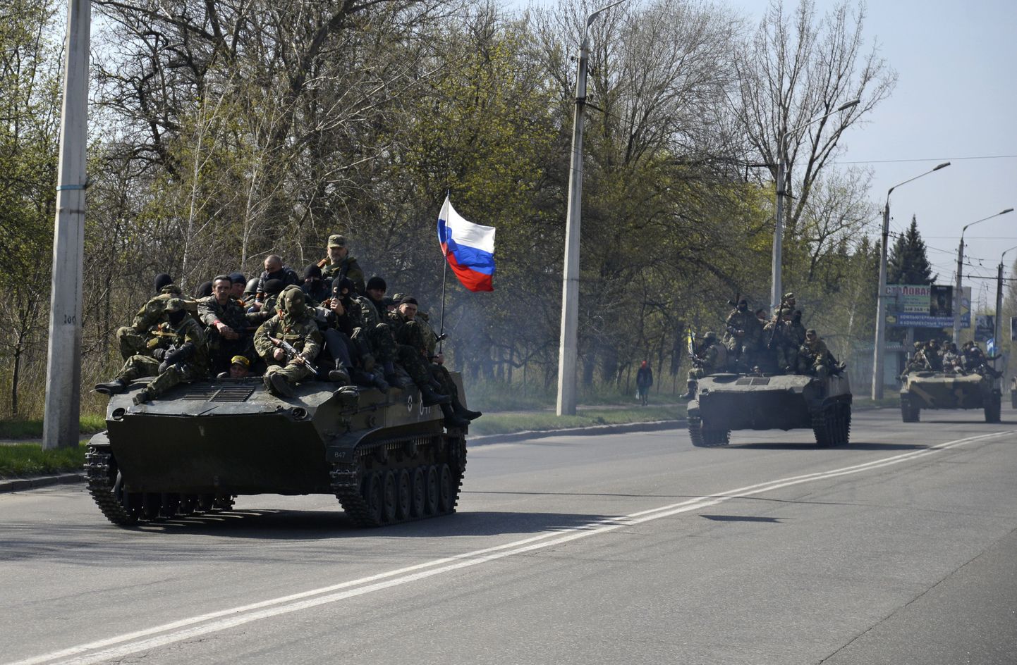 Maskides mehed soomukitel ja soomustransportööridel, millel lehvivad Vene lipud, teel Kramatorskisse.