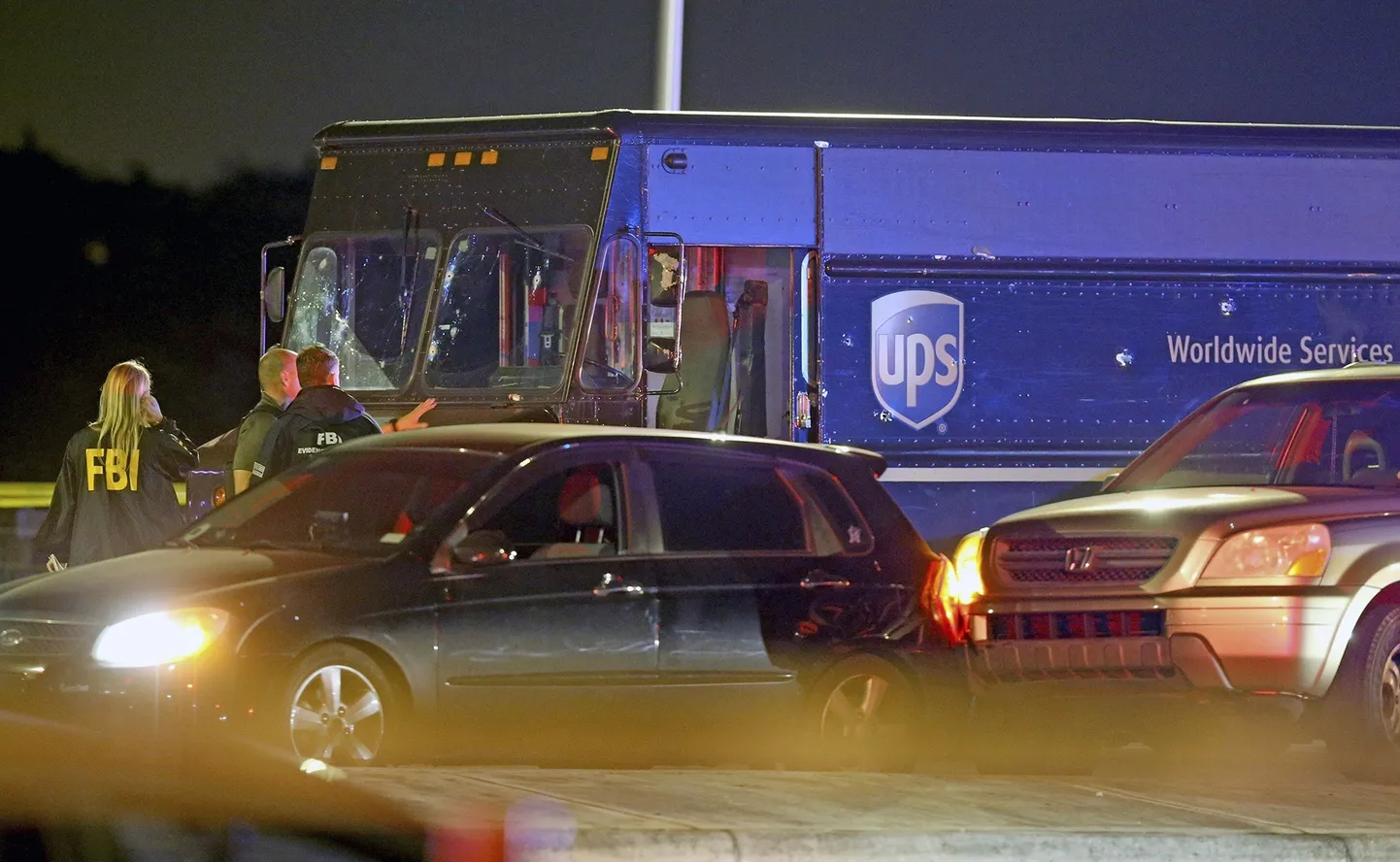 Korrakaitsjad seismas UPS-i veoki kõrval, mis on osa nelja inimese surmaga lõppenud tagaajamise kuriteopaigast.