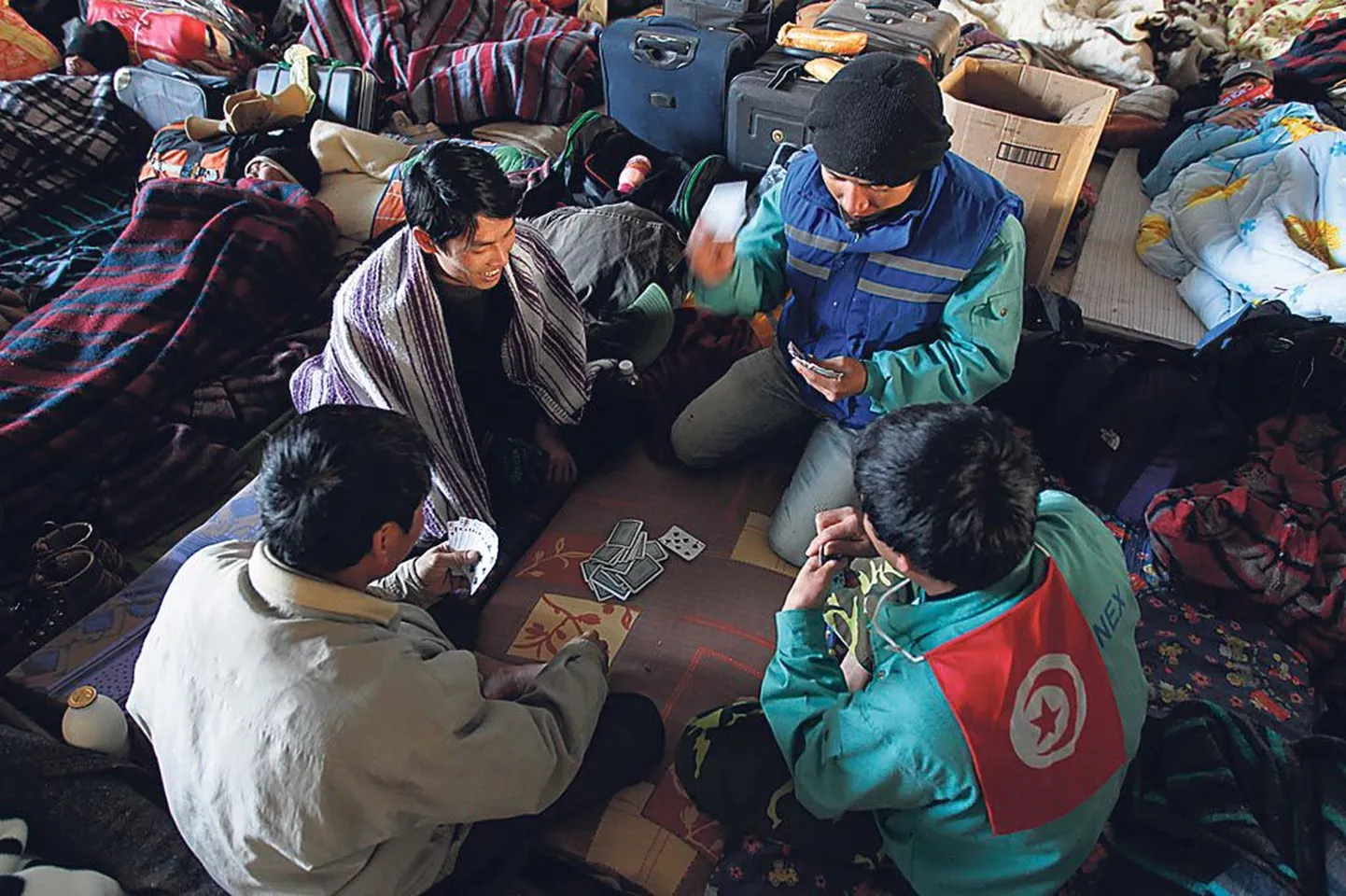 Vietnami võõrtöölised mängivad kaarte, oodates kodumaale sõitu Liibüa naaberriigis Tuneesias.