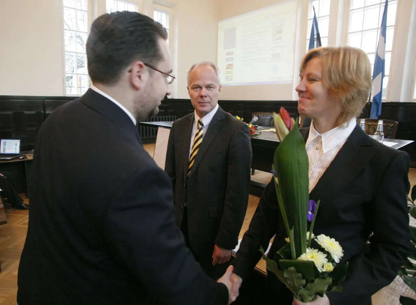 Endine linnapea Mart Viisitamm rahanduse abilinnapead Annely Akkermanni õnnitlemas. Taamal seisab uus linnapea Toomas Kivimägi.
