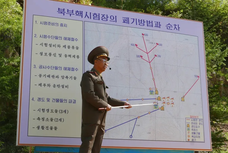 Põhja-Korea hävitas välisajakirjanike ees tuumakatsetuste polügooni. Põhja-Korea sõjaväelane jagamas enne polügooni hävitamist selgitusi