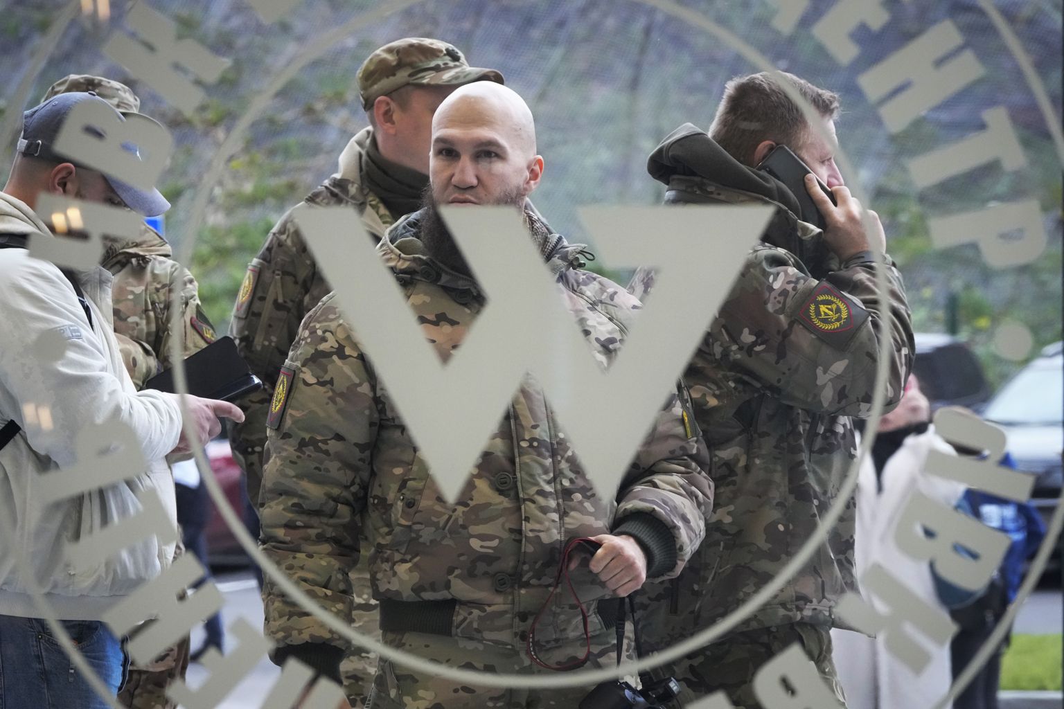Sõjaväe riideid kandvad külastajad seisavad PMC Wagneri keskuse sissepääsu juures,