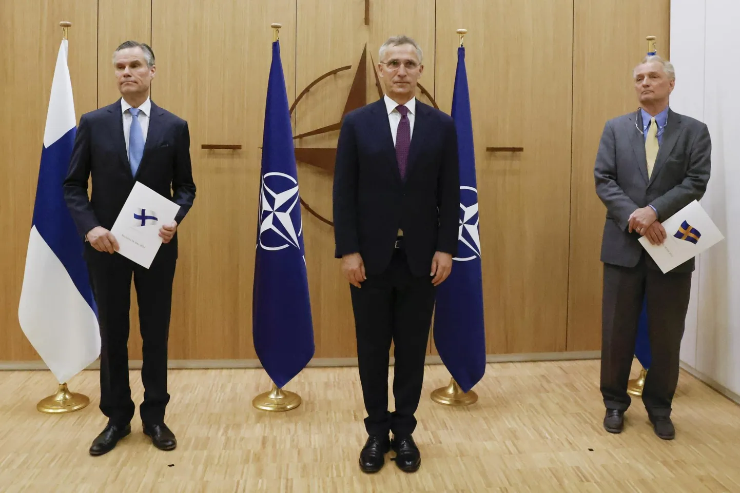 NATO peasekretär Jens Stoltenberg (keskel) ootab Soome ja Rootsi saadikutelt NATO juures (vastavalt vasakul ja paremal) NATOga liitumise avaldust. 