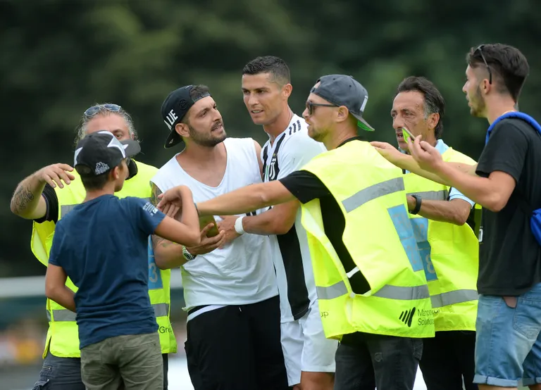 Cristiano Ronaldot ümbritsevad väljakule jooksnud toetajad.