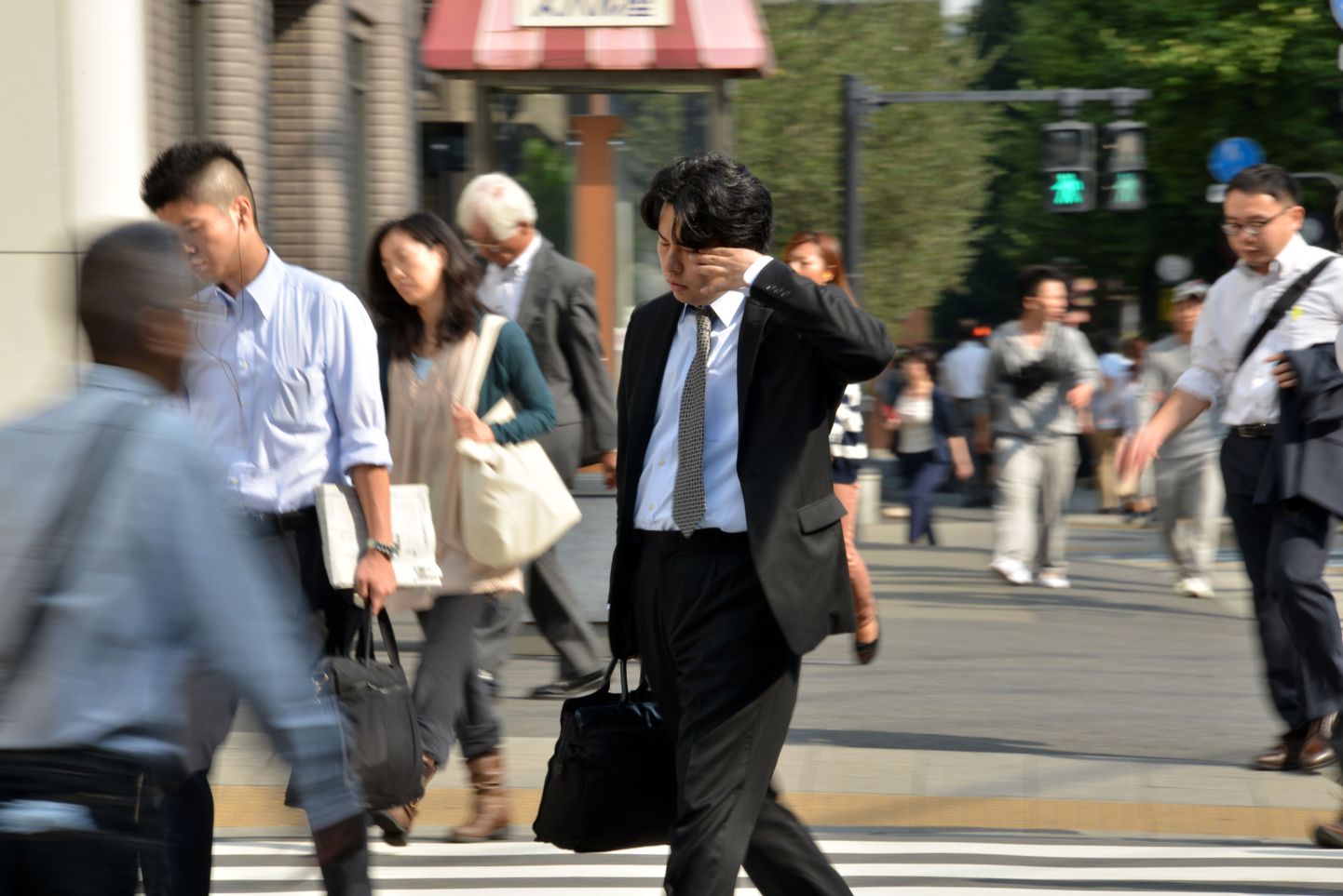 Jaapani palatööline tööle kõndimas ja silmist und pühkimas.
