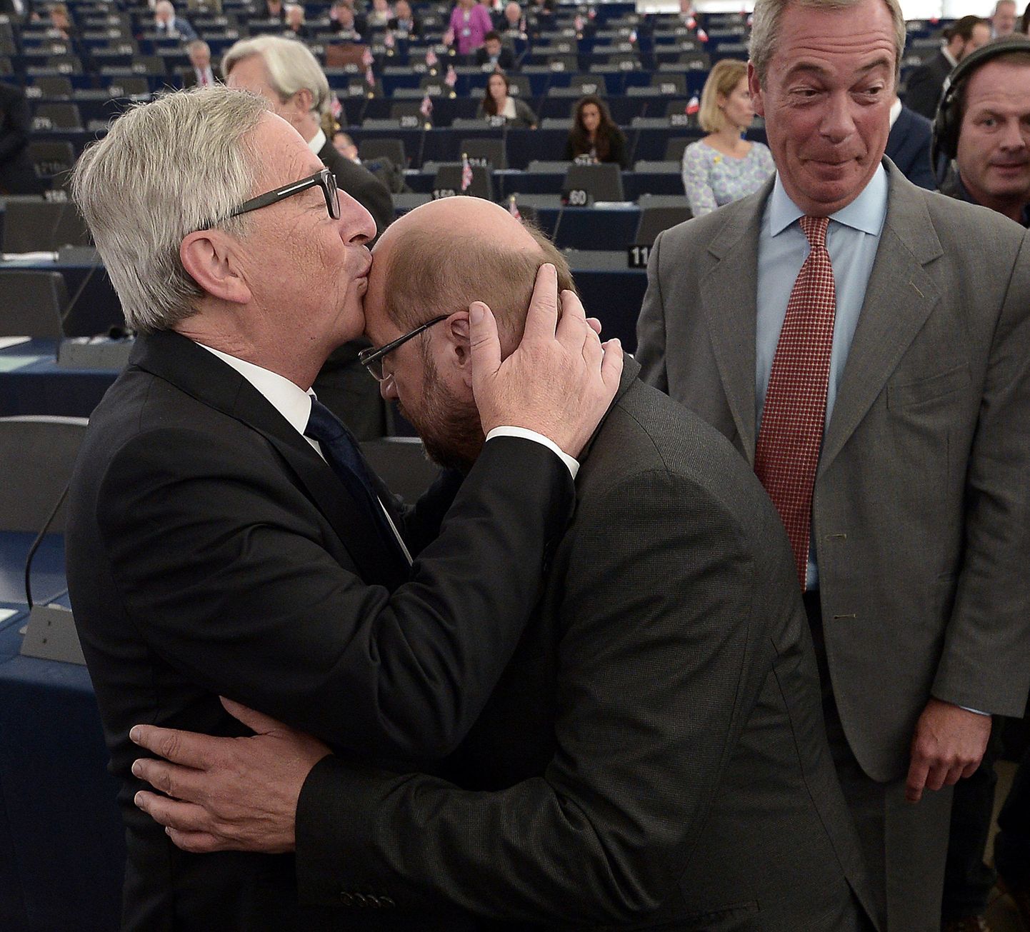 Euroopa Parlamendi presidenti Martin Schulzi on suudlemas laubale Euroopa Komisjoni president Jean-Claude Juncker. Pilgu on pööranud kõrvale Briti iseseisvuspartei UKIP liider Nigel Farage (paremal).