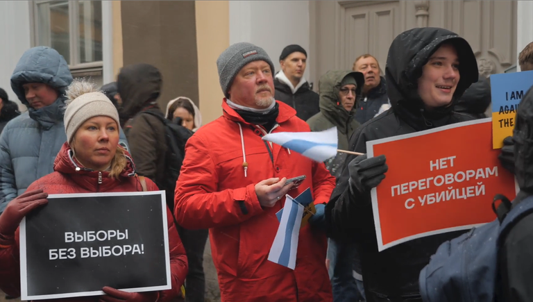 Небольшой митинг протеста прошел на узкой таллиннской улочке у входа на участок для голосования.