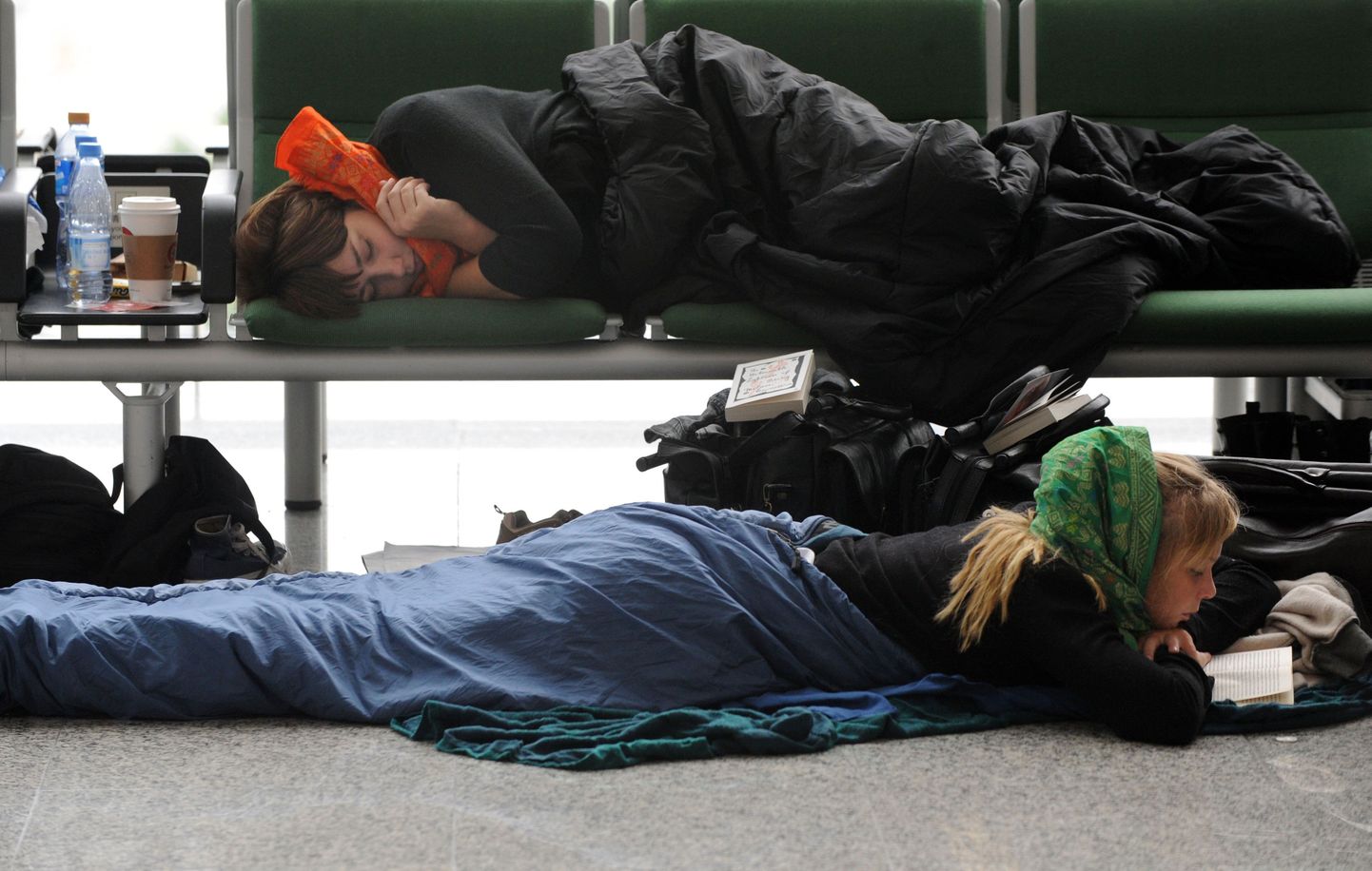 Kaks naist täna magamiskottides Hong Kongi lennujaamas. Tuhanded eurooplased ei pääse lennukeelu tõttu Aasiast tagasi kodumaale.