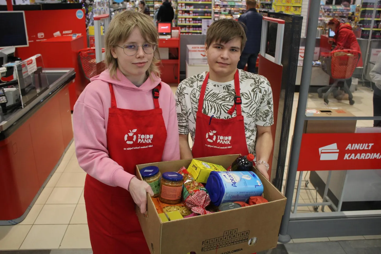 Teele Ann Tint ja Karmo Lill annetatud toiduga Põhjakeskuse Rimi juures.