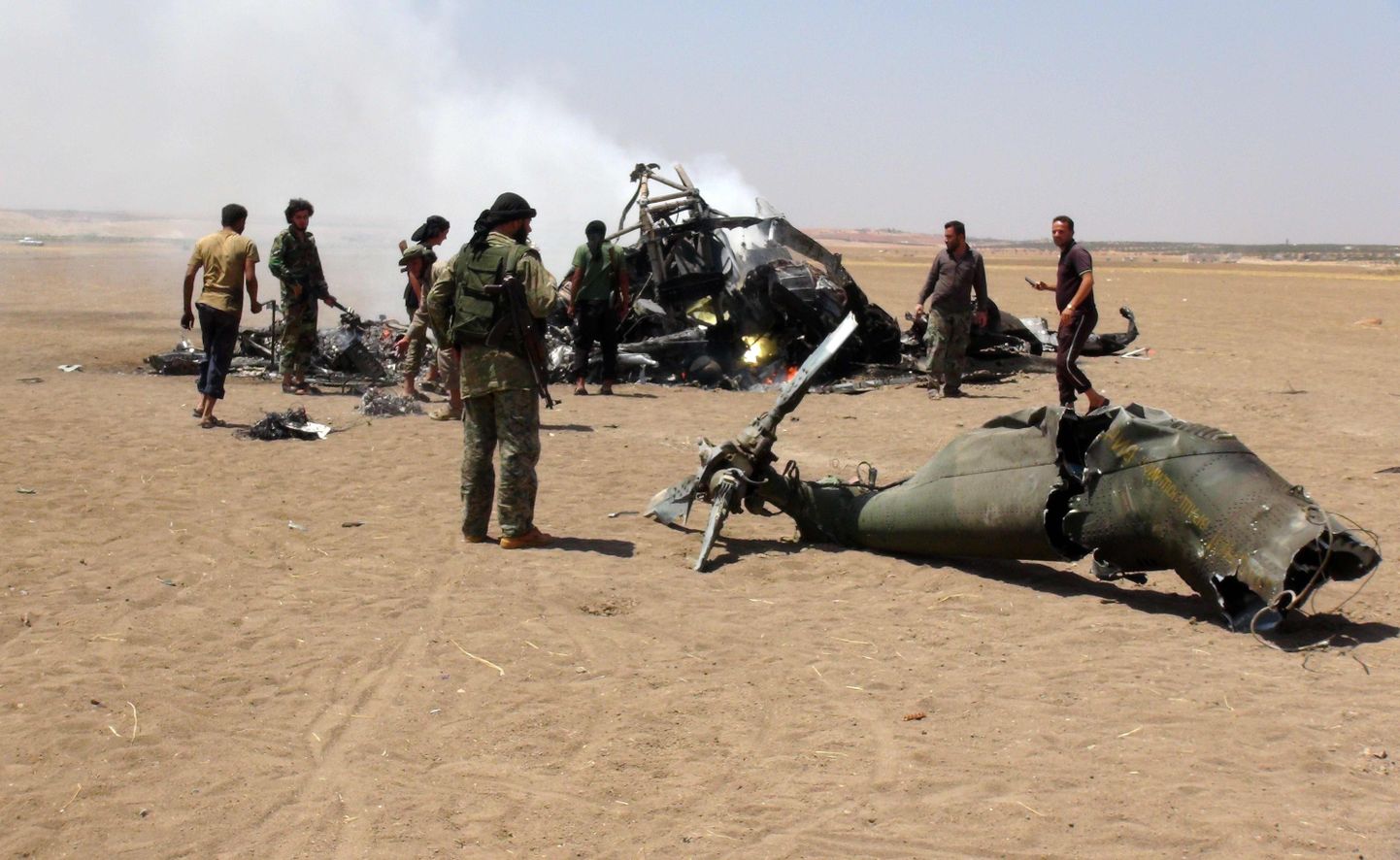 Allatulistatud Vene sõjaväe helikopteri juurde kogunenud võitlejad eile Kirde-Süürias.