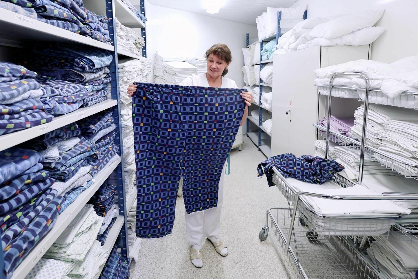 Tartu ülikooli kliinikumi pesukäitluse juht Ivi Albrecht näitamas pidžaamapükse suuruses 68.
