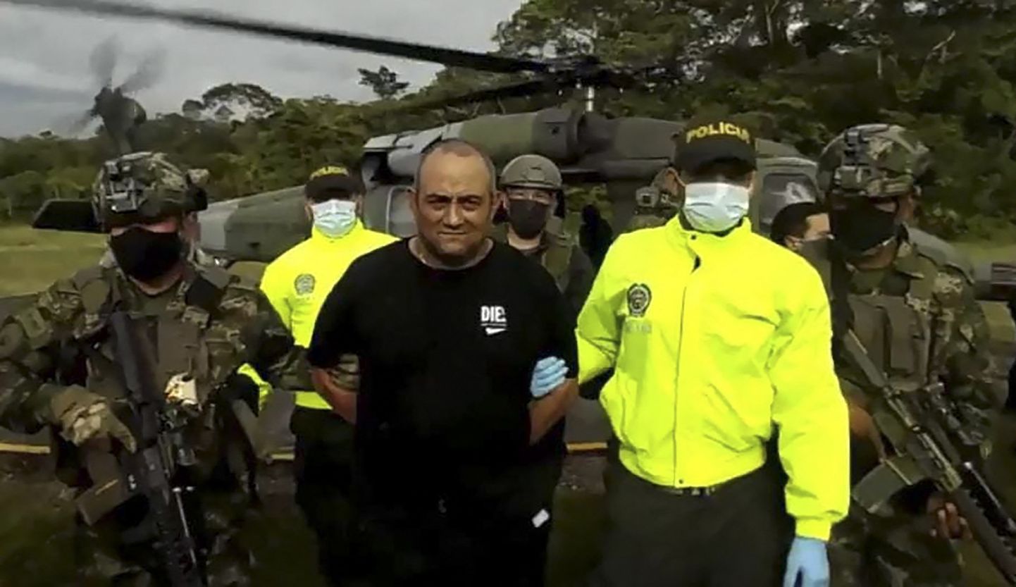Colombia armee ja politsei esindajad eskordivad mullu oktoobris tabatud uimastiparunit Dairo Antonio Usugat, kelle tabamise eest panid USA võimud välja viie miljoni dollari suuruse vaevatasu.