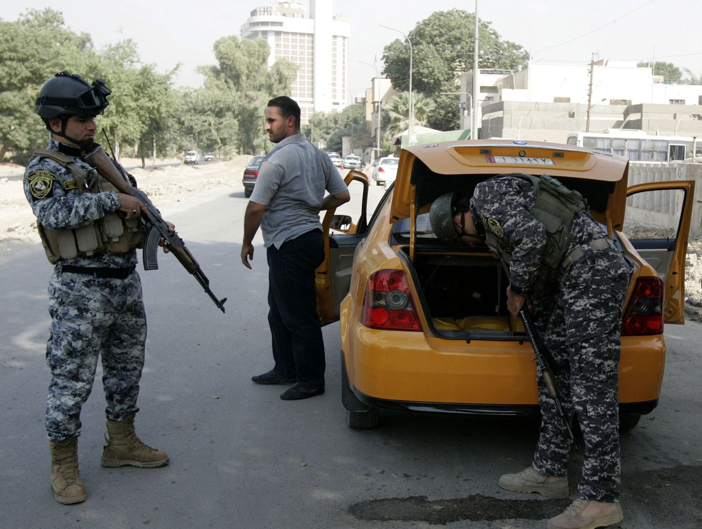 Iraagi politseinikud kontrollpunktis autot läbi otsimas.