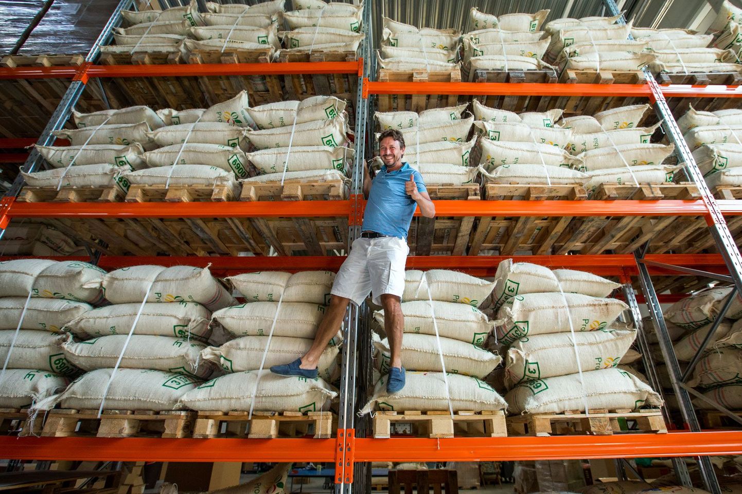 Член правления Coffe People OÜ Аннар Алас позирует на стеллажах склада, где размещается 40 тонн кофейных зерен, привезенных в Эстонию прямо от производителей из разных уголков света.
