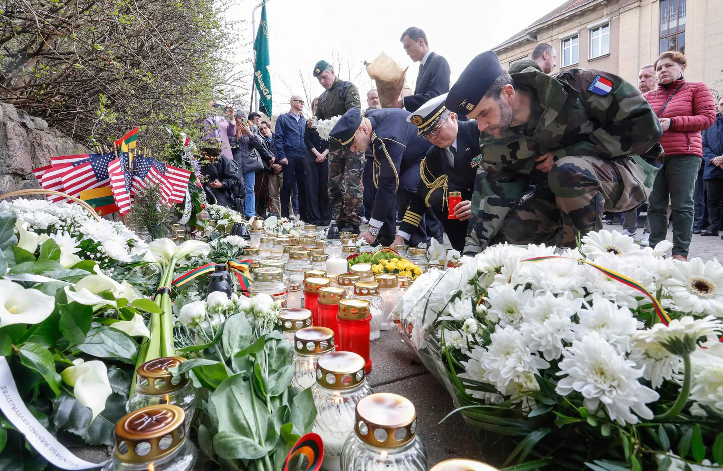 NATO sõdurid viivad lilli ja küünlaid Pabradė harjutusalal hukkunud USA sõdurite mälestuseks USA saatkonna ette Vilniuses, 1. aprillil 2025. a.