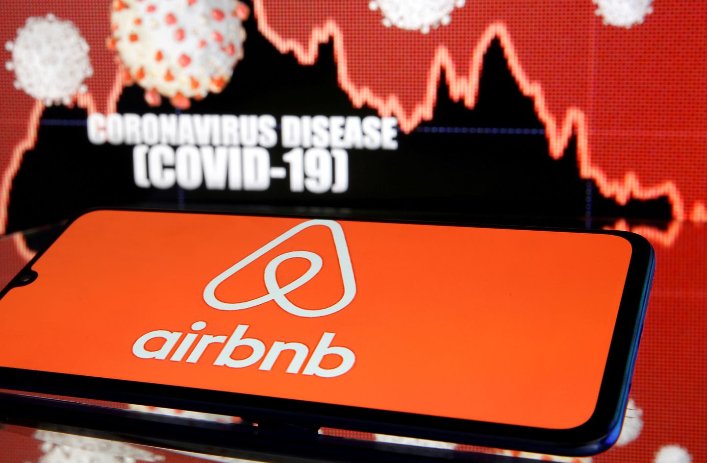 Airbnb logo is koroonaviiruse graafiku ees.