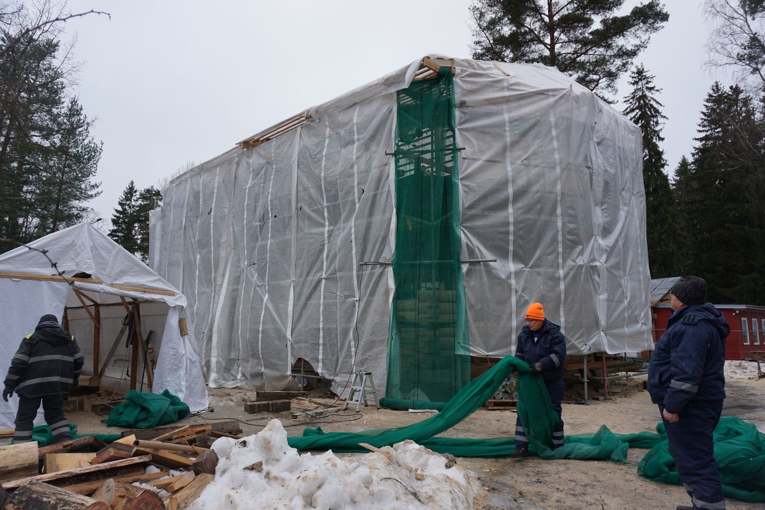 Растут стены церкви в Нарва-Йыэсуу: под большой палаткой идет строительство, в маленькой - обрабатывают бревна.