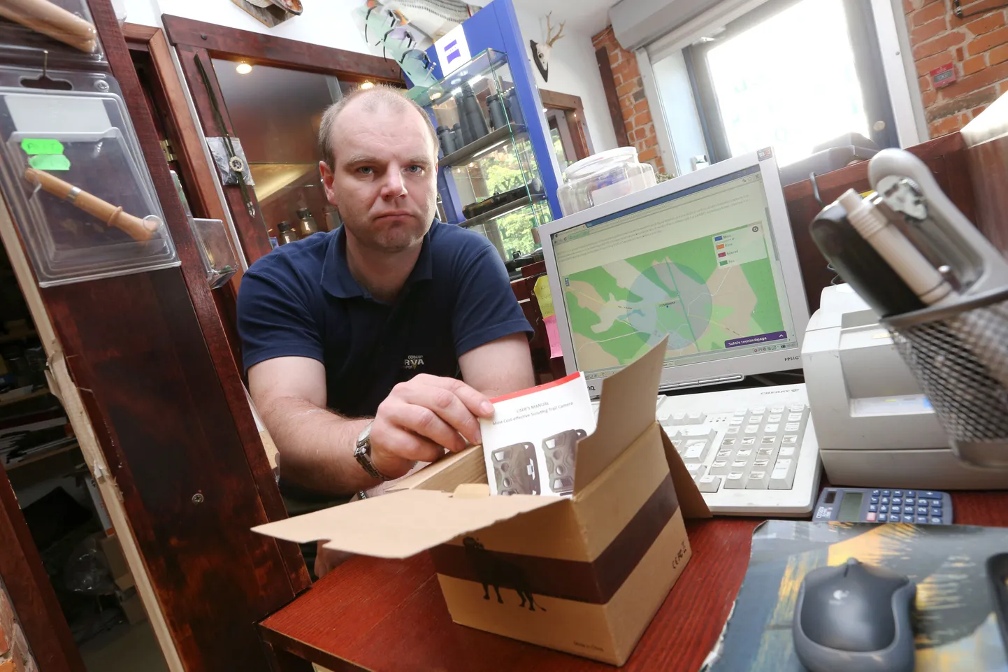 Janek Reiljan näitab tühjaks jäänud rajakaamerakarpi. Tema arvutiekraan aga kuvab siiani kaamera praegust asukohta Jõhvi-Tartu maantee ääres.