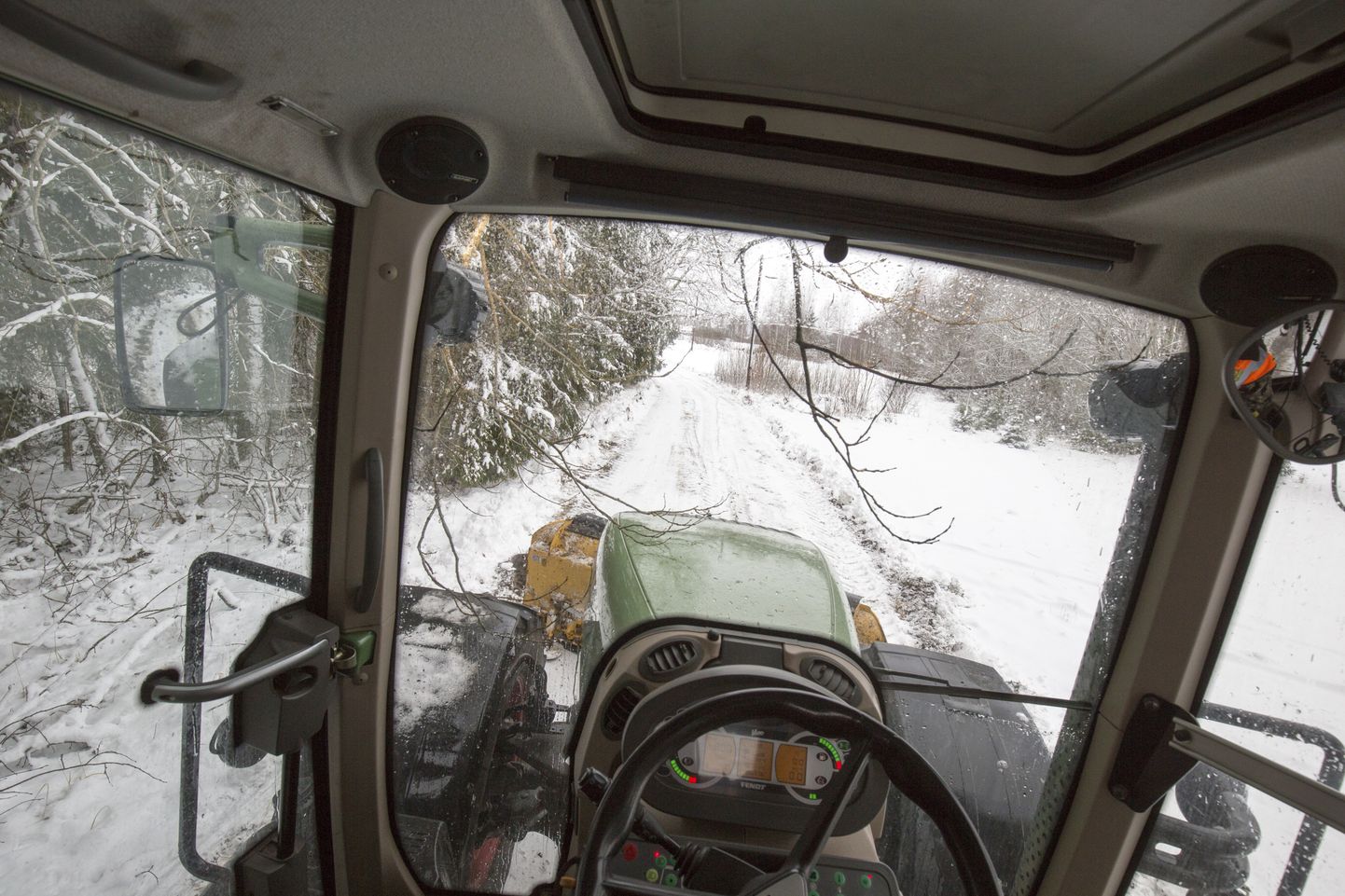 Lume raskuse all tee kohale looka vajuvad oksad võivad ära lõhkuda teed lahti lükkava traktori tuled ja peeglid. Foto on tehtud eile päeval Mulgi vallas Kaarli külas.