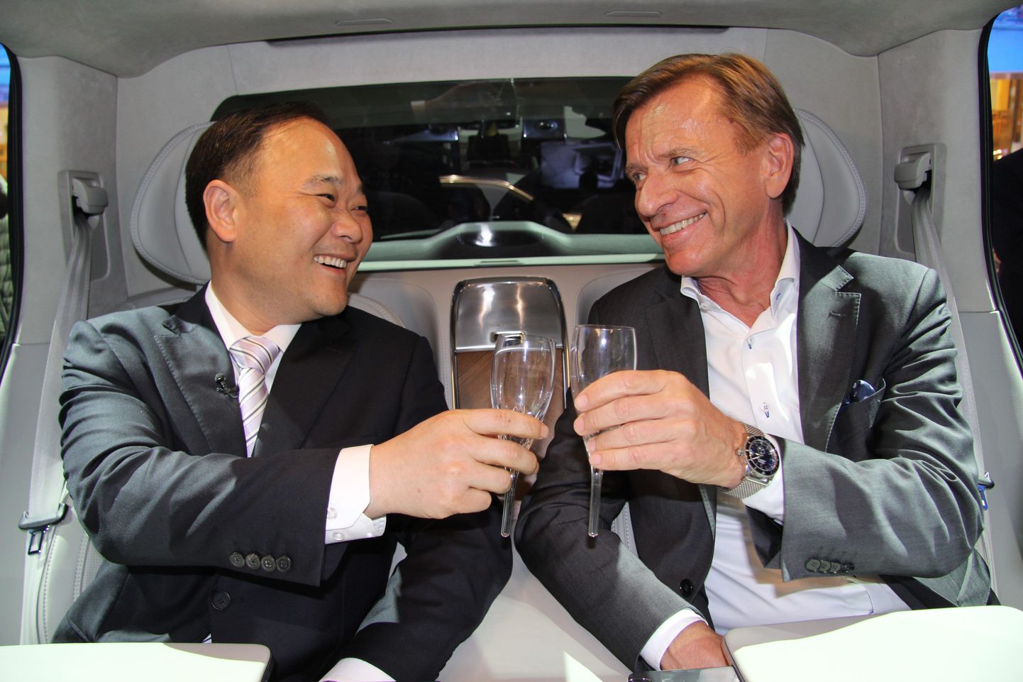 Volvo Carsi juhatuse esimees Li Shufuja tegevjuht Håkan Samuelsson löövad Shanghai autonäitusel Volvo XC90 Excellence'i tagaistmel klaase kokku.