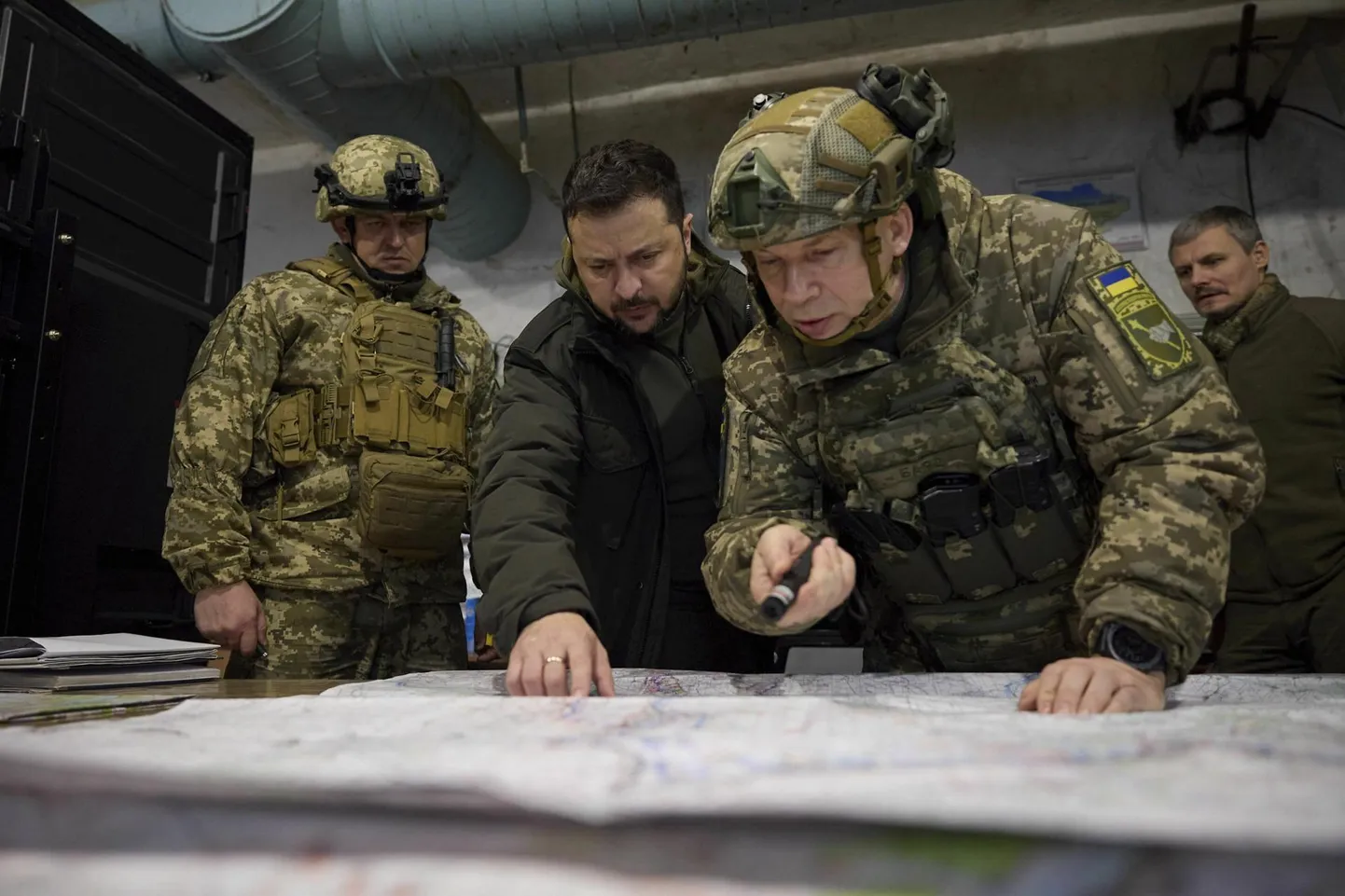 Ukraina president Volodõmõr Zelenskõi (keskel) uurimas sõjakaarti koos Kupjanski taktikalise üksuse komandöri Oleksandr Lutsenko (vasakul) ja toonase maaväe ülema Oleksandr Sõrskõiga 30. novembril 2023 Harkivi oblastis Kupjanskis.