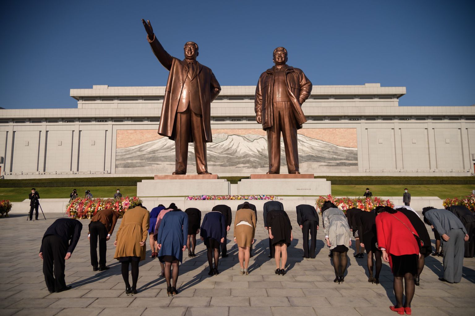 Põhjakorealased kummardavad riigi eelmiste diktaatorite Kim Il Sungi and Kim Jong Ili kujude ees töölispartei 75. aastapäeval 10. oktoobril 2020