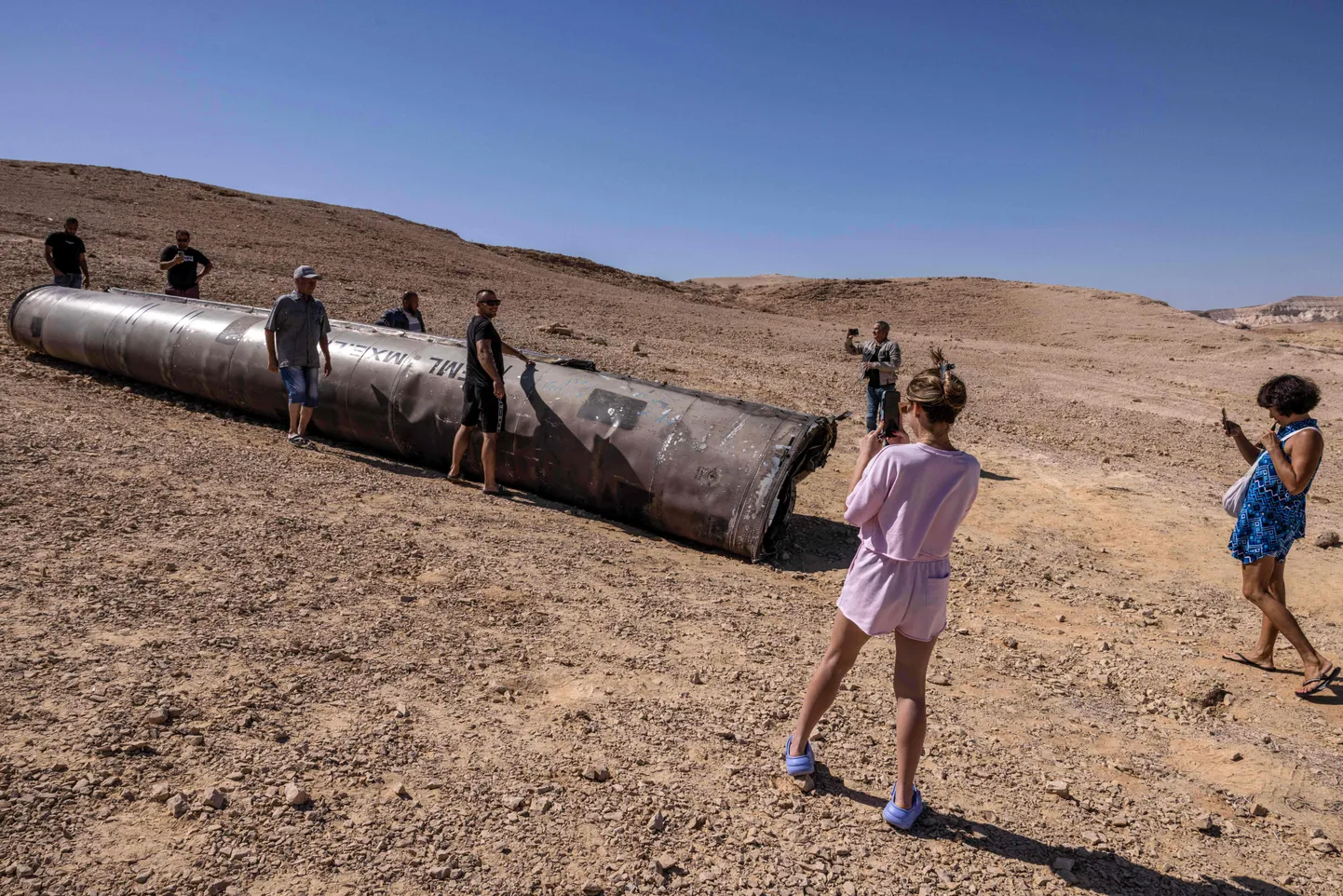 Inimesed poseerivad Iraani raketi jäänuste juures Negevi kõrbes Iisraelis.