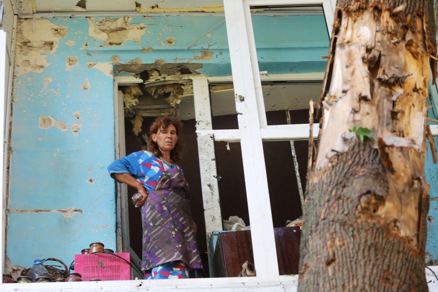 Ida-Ukrainas asuva Horlivka elanik mürsurünnakus kannatada saanud kodu ees.