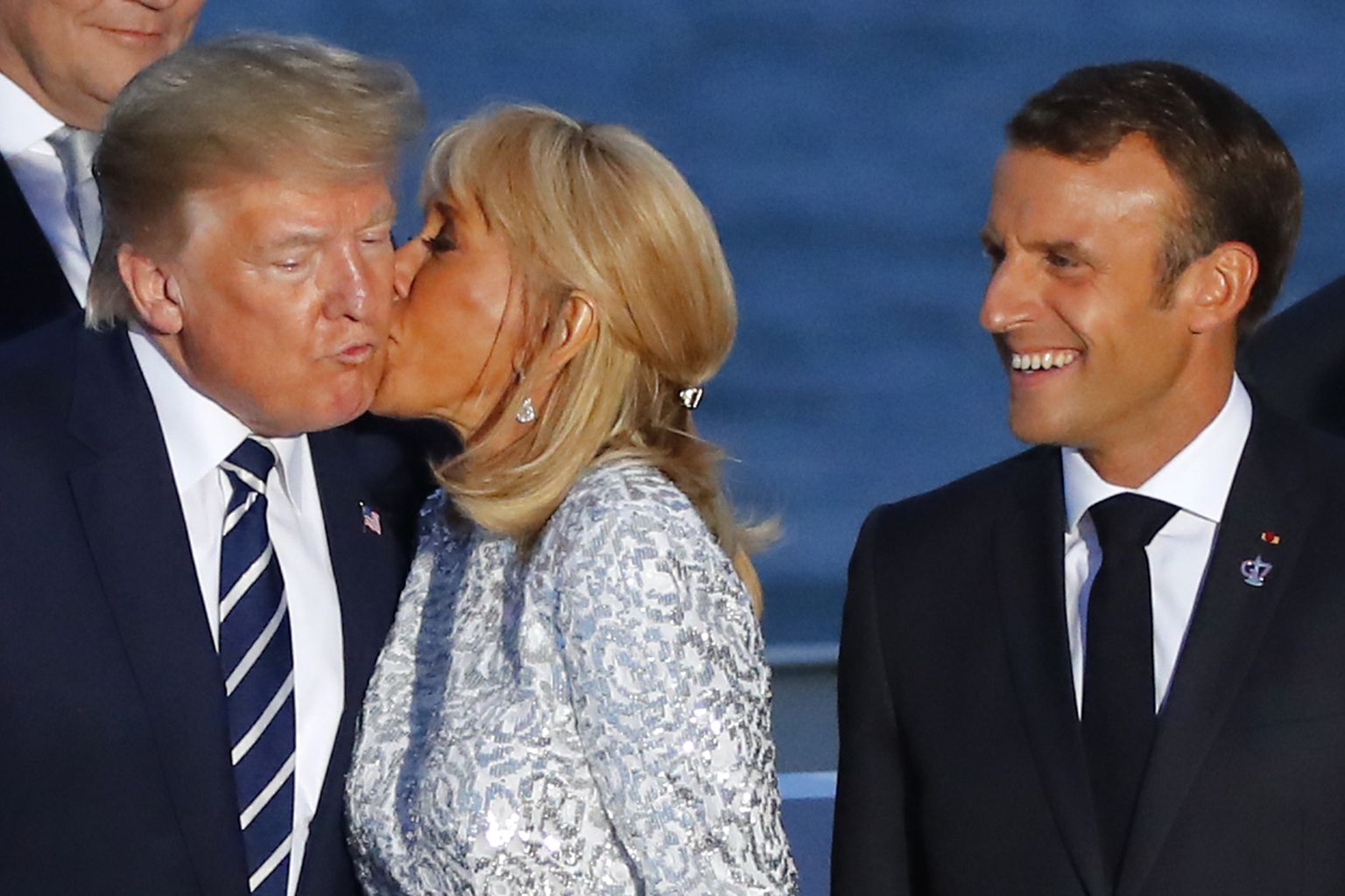 Prantsuse president Emmanuel Macron (paremal) vaatamas 25. augustil 2019, kuidas ta naine Brigitte Macron suudleb USA presidenti Donald Trumpi G7 riikide tippkohtumisel Prantsusmaal Biarritzis