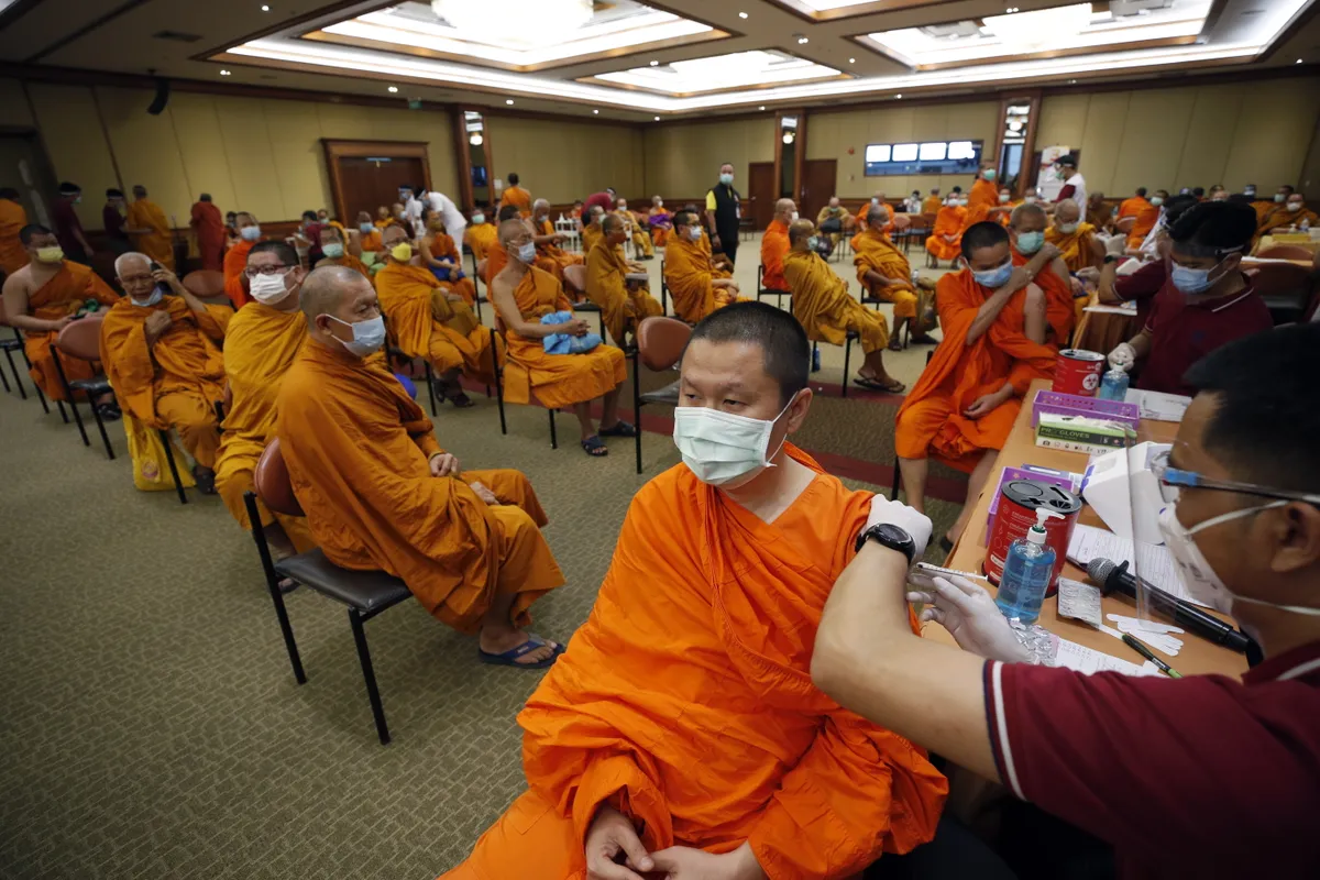 Budistu mūki vakcinējas slimnīcā Bangkokā, Taizemē.