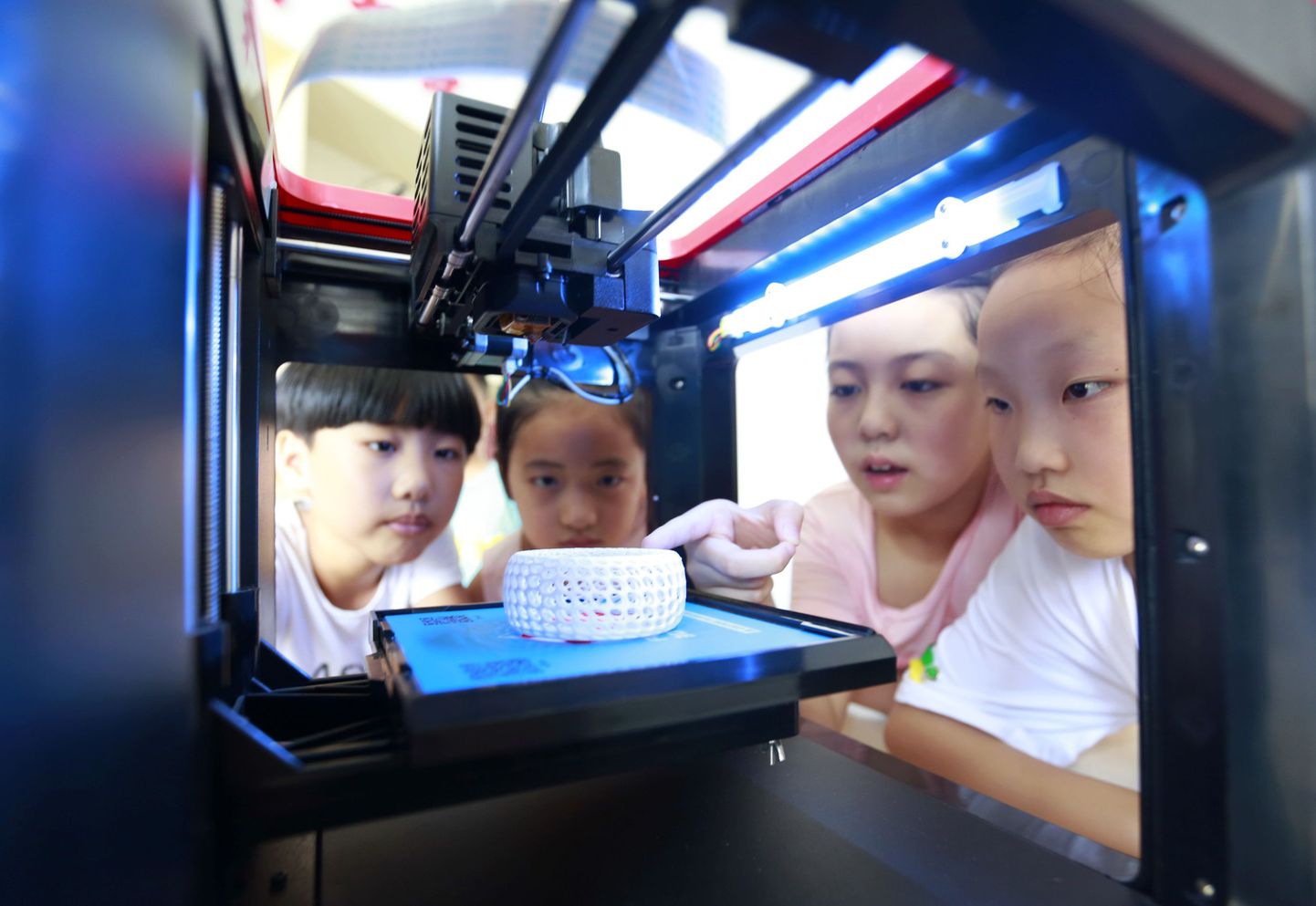 Lapsed vaatavad kuidas 3D printer töötab teaduse ja tehnoloogia muuseumis.