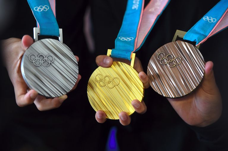 The PyeongChang 2018 Olympic medals are displayed by young South Korean athletes during their unveiling at a ceremony in Seoul on September 21, 2017.T/ AFP PHOTO / JUNG Yeon-Je