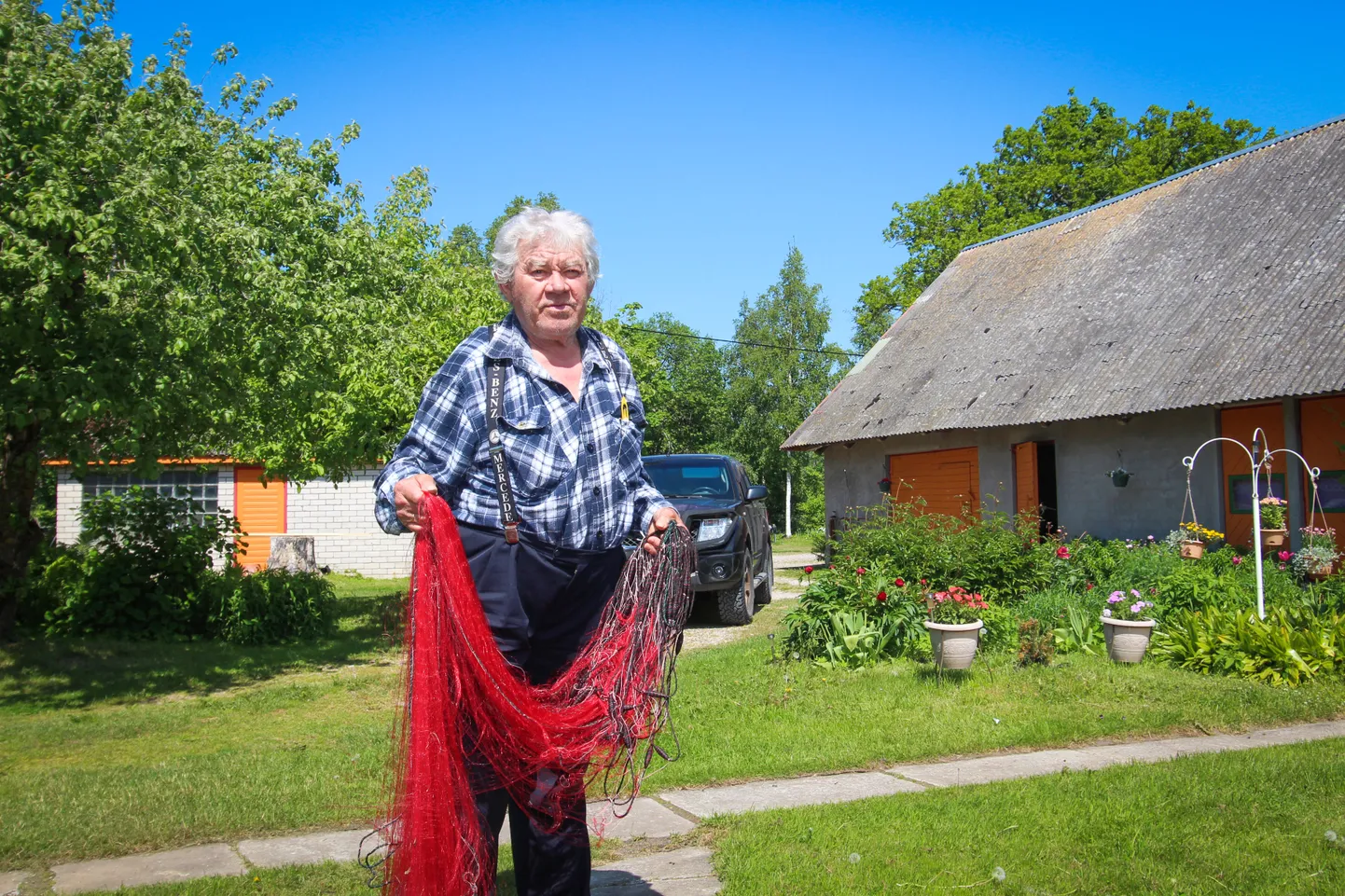 VÕRGUD VAJA KLAARIDA: Kalapaati astub Tehumardi küla mees Eino Ruttu Salme jõesadamas. Püügivahendid on ta koduõues ette valmistanud.