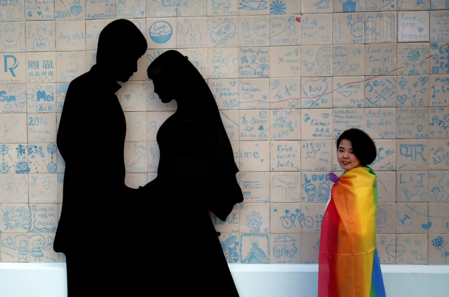 A participant poses next to a wedding studio during a lesbian, gay, bisexual and transgender (LGBT) pride parade to support same-sex marriage in Taipei, Taiwan, October 27, 2018. REUTERS/Tyrone Siu     TPX IMAGES OF THE DAY