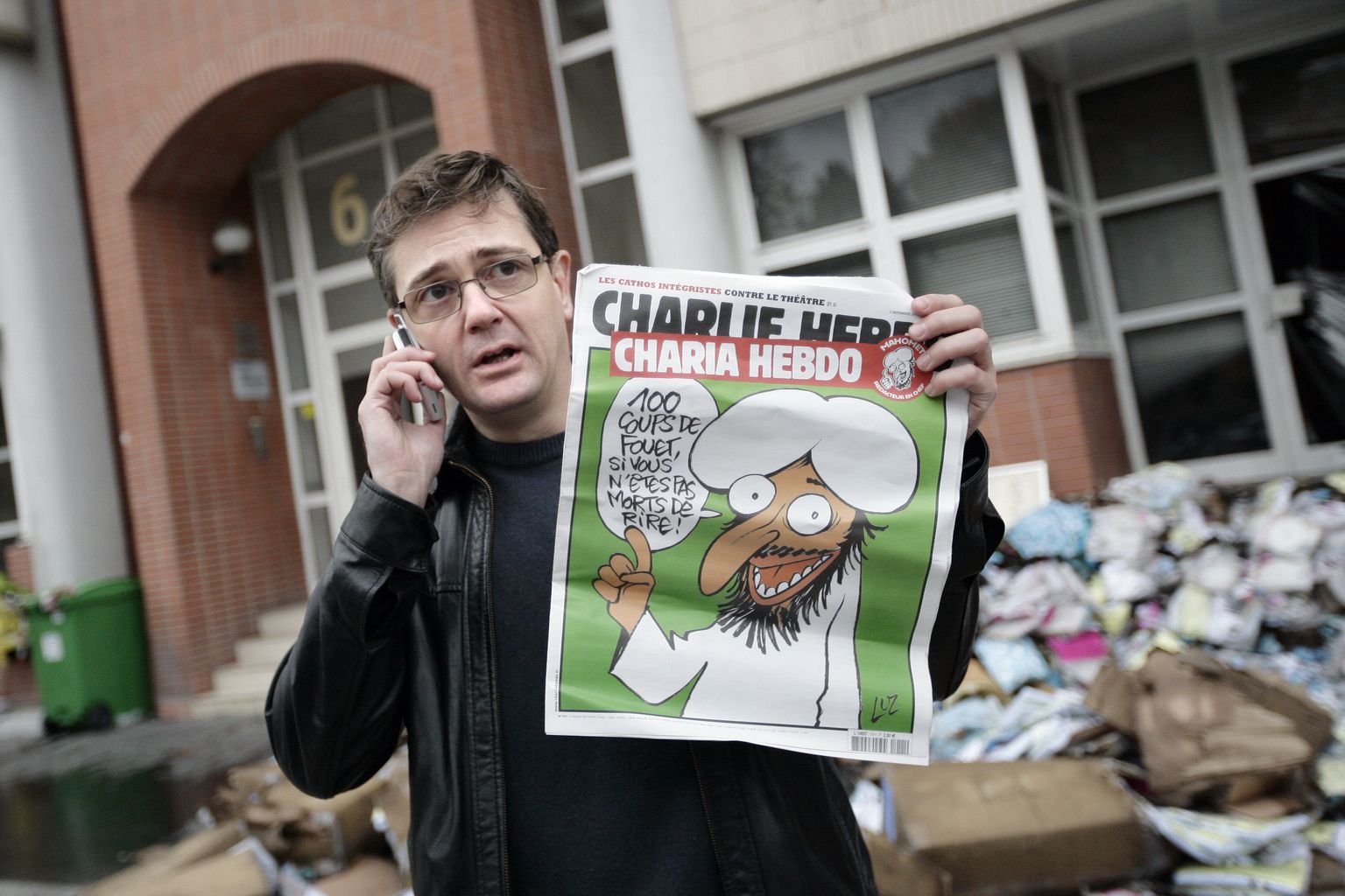 Charlie Hebdo peatoimetaja Stéphane Charbonnier, karikaturistinimega Charb, näitamas 2011 prohvet Muhamediga esikaanel lehte