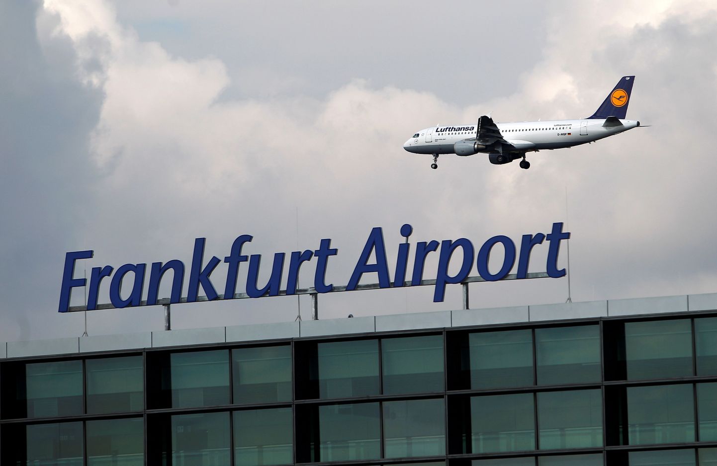 An aircraft of German air carrier Lufthansa flies beyond the A-Plus terminal section at the Fraport airport in Frankfurt, Germany September 28, 2012.  REUTERS/Lisi Niesner/File Photo
