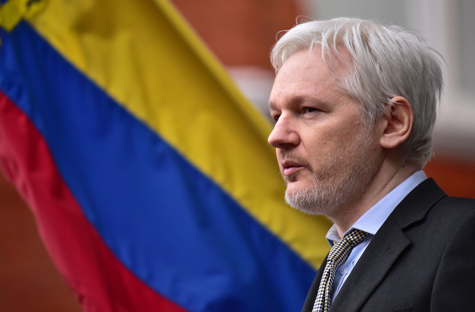 Julian Assange ja tema taga lehviv Ecuadori lipp.