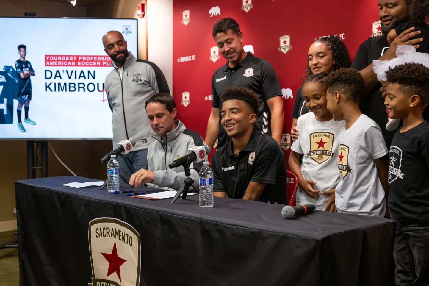 Da'vian Kimbrough (istub keskel) koos perekonna ja Sacramento jalgpalliklubi esindajatega allkirjastamas profilepingut.