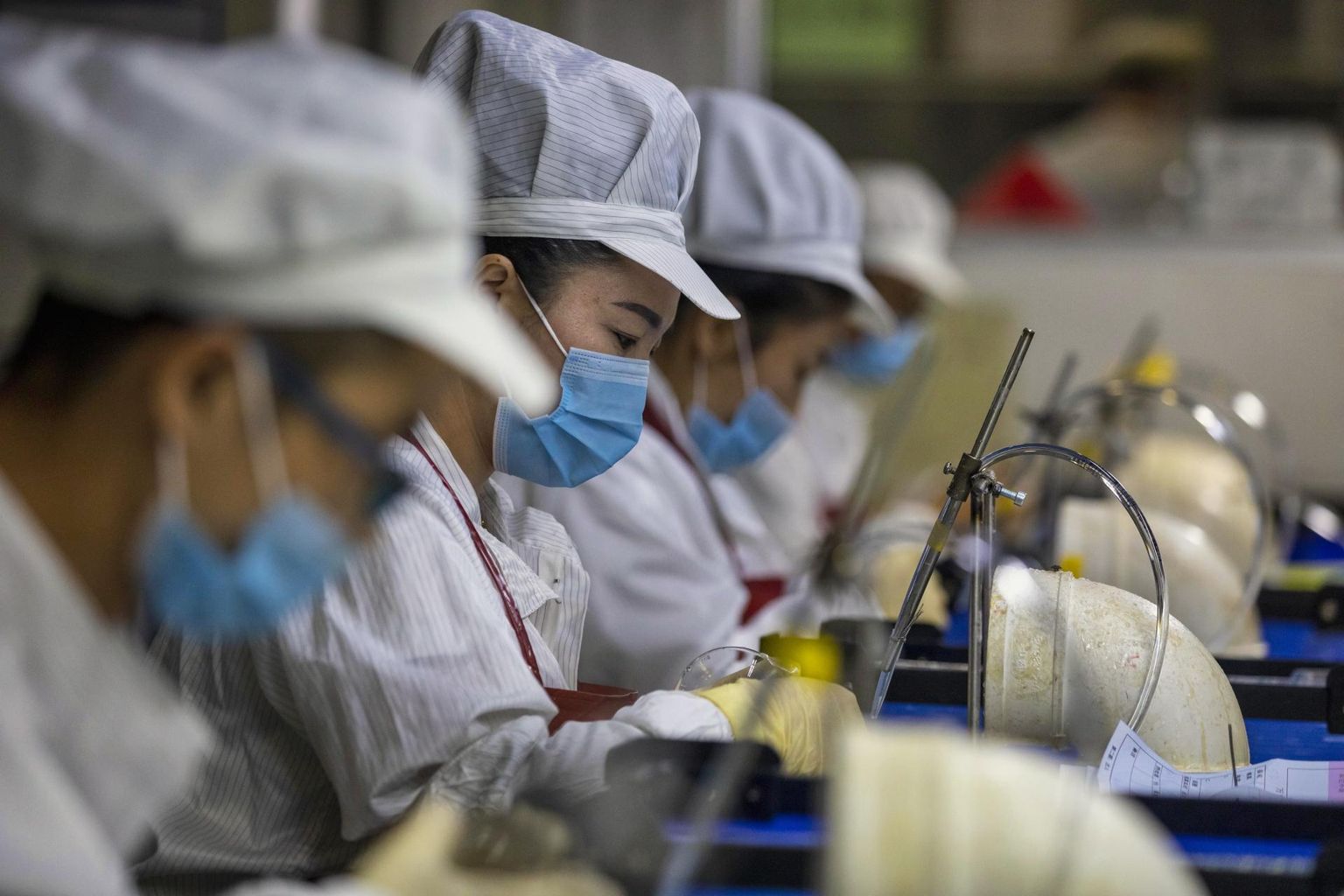 Hiina töölised valmistamas Jiangsu provintsis Zhenjiang asuvas Wanxini tehases otilisi läätsi.