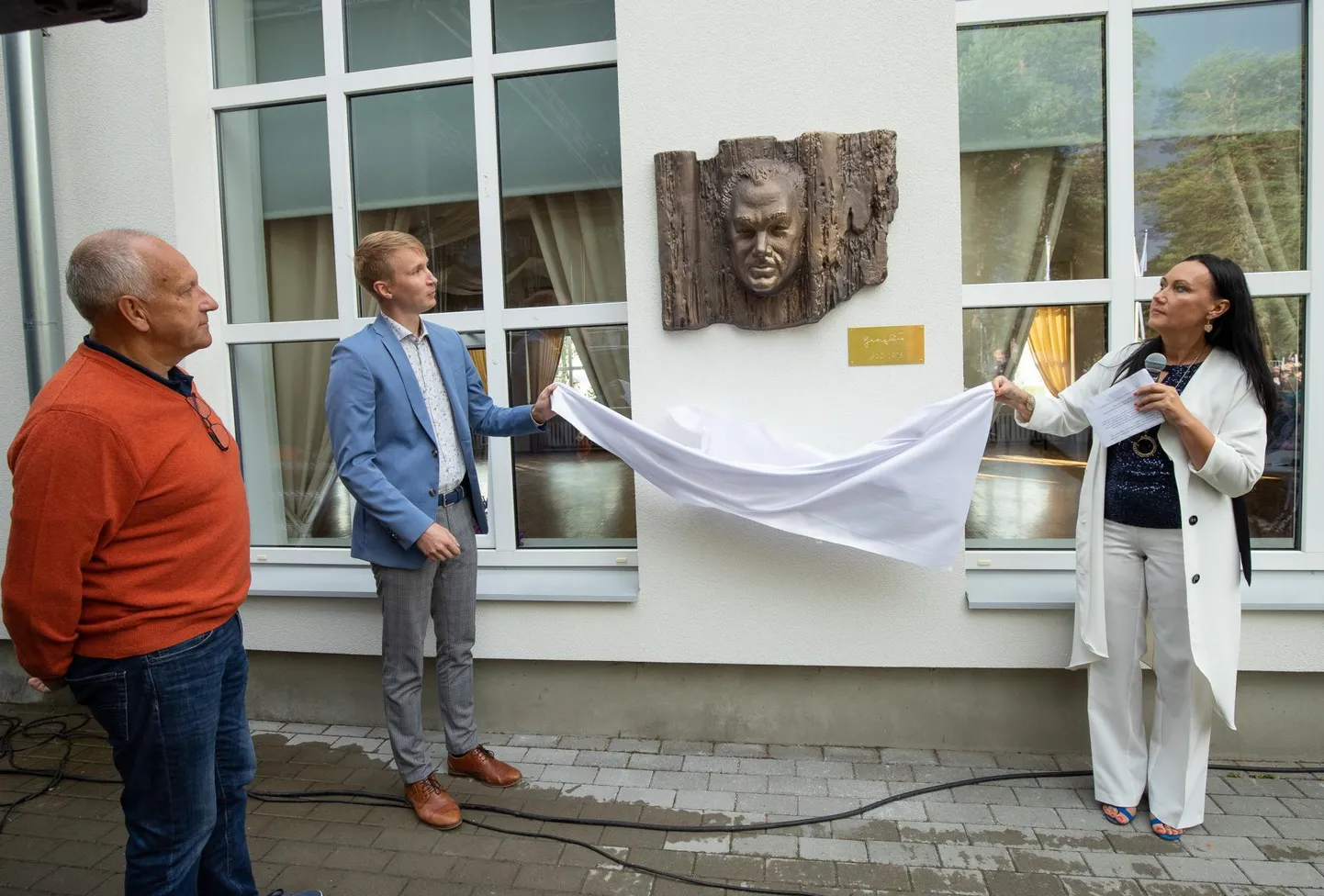 Georg Otsa bareljeefilt eemaldasid katte Haljala vallavolikogu esimees Vello Väinsalu (vasakul) ja vallavanem Ivar Lilleberg ning bareljeefi rannahoone seinale paigutamise initsiaator Hannula Lepp.