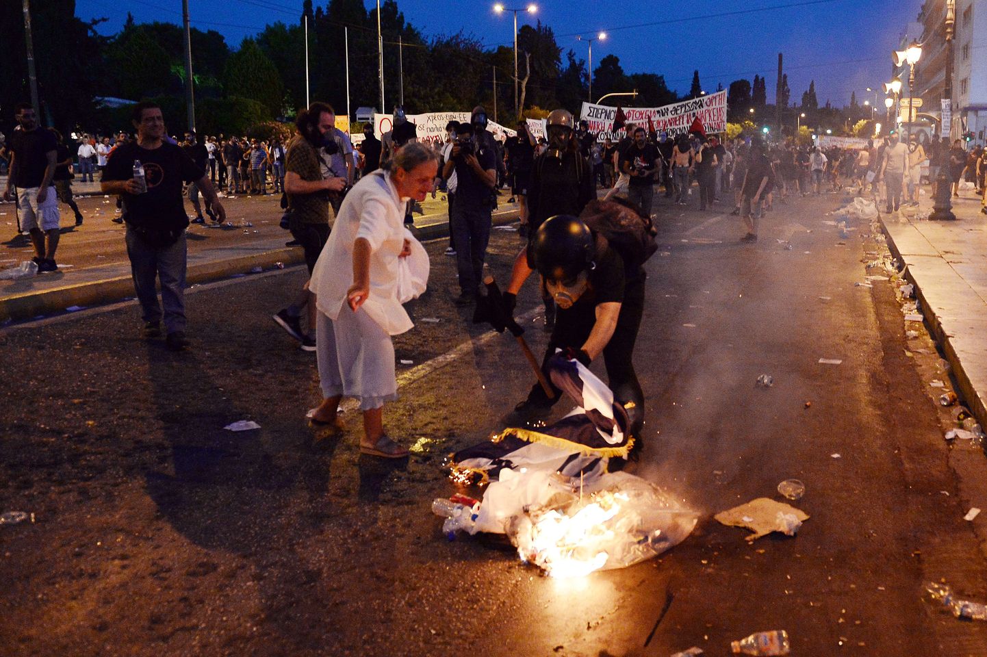 Protestija põletab kasinusvastasel meeleavaldusel Kreeka lippu.