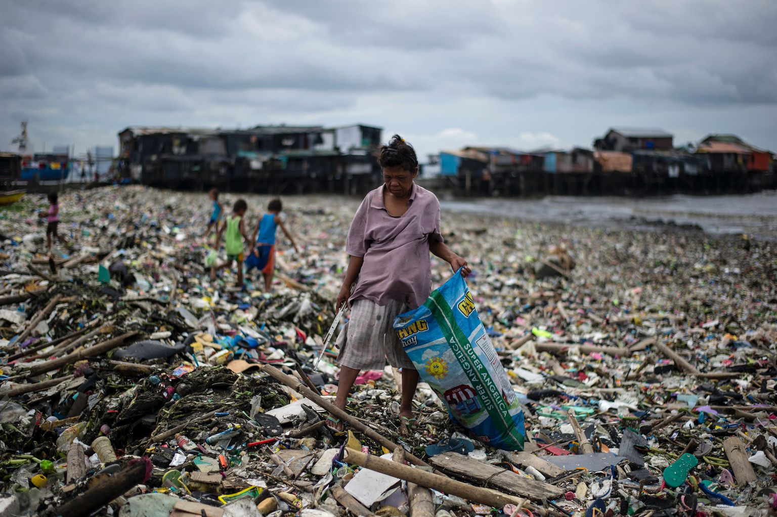 taarakorjaja Manila rannas. Tulevikus võivad bakterid plastpudelid lihtsalt ümber töödelda