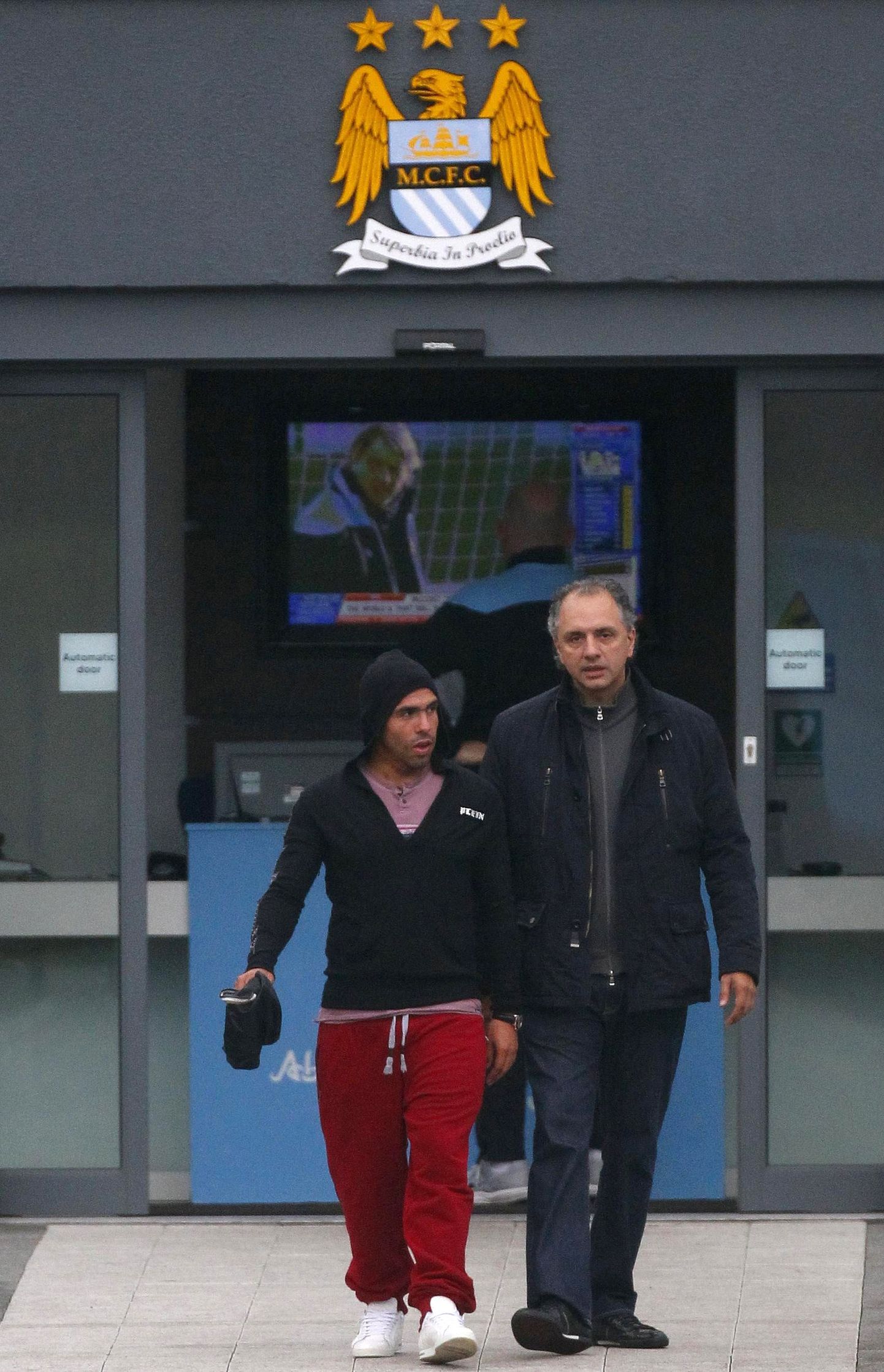 Carlos Tevez (vasakul) Manchester City treeningväljakult lahkumas.
