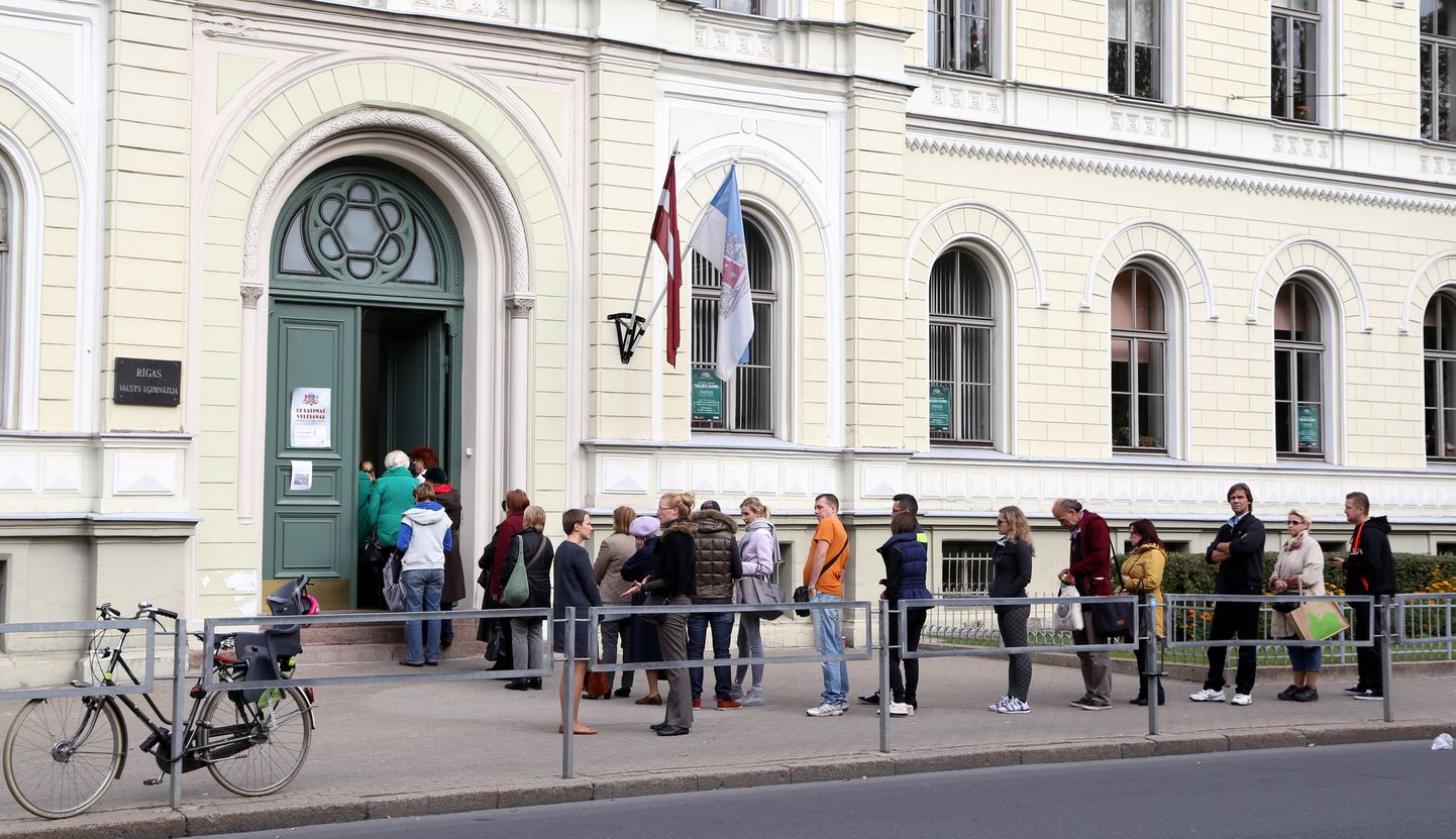 Cilvēki stāv rindā pie 3.vēlēšanu iecirkņa, lai nodotu savu balsi 12. Saeimas vēlēšanās.