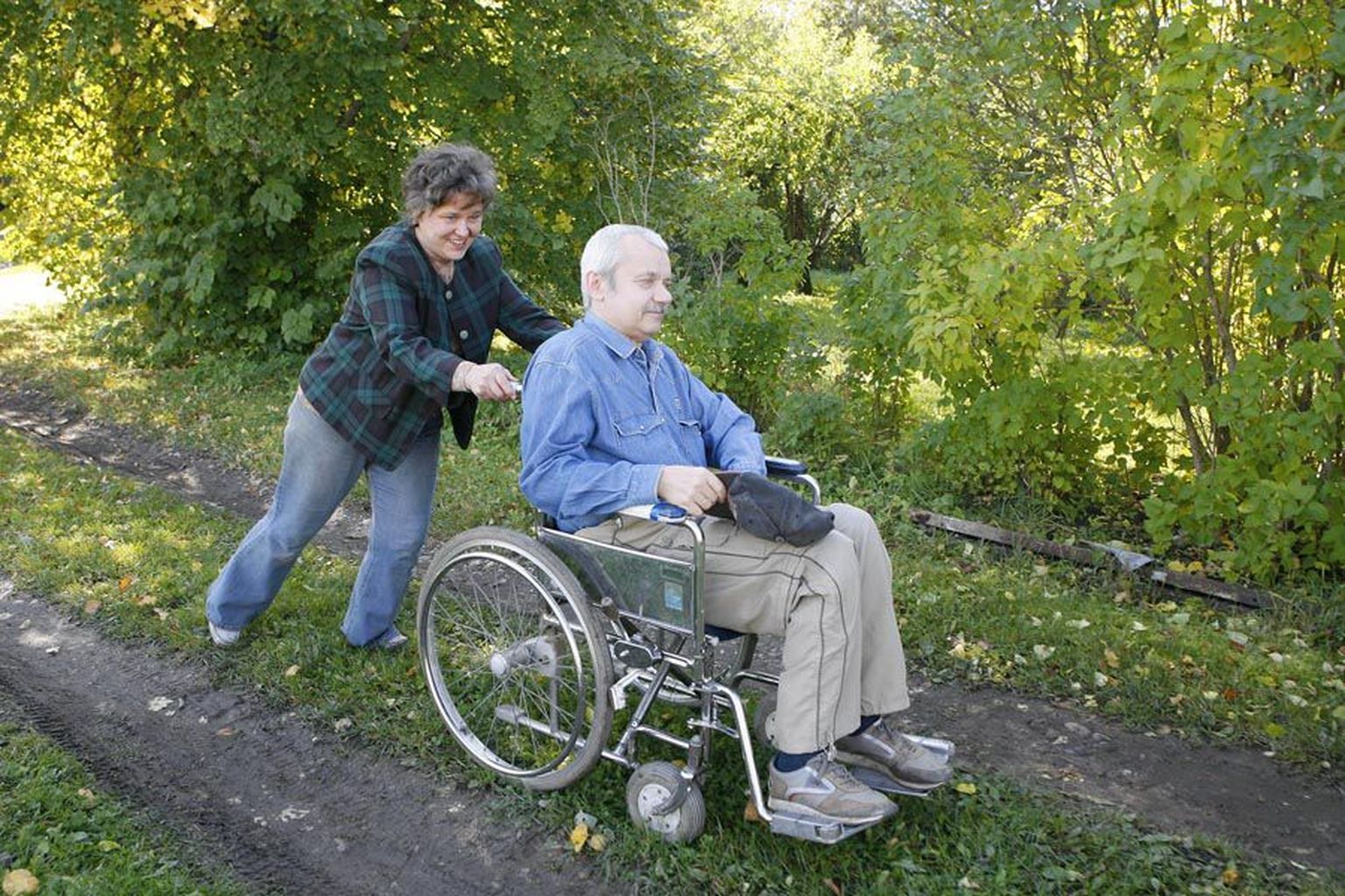 Imbi Kask lükkab mehe ratastoolis õueväravani, kaugemale sel moel ei jõua.