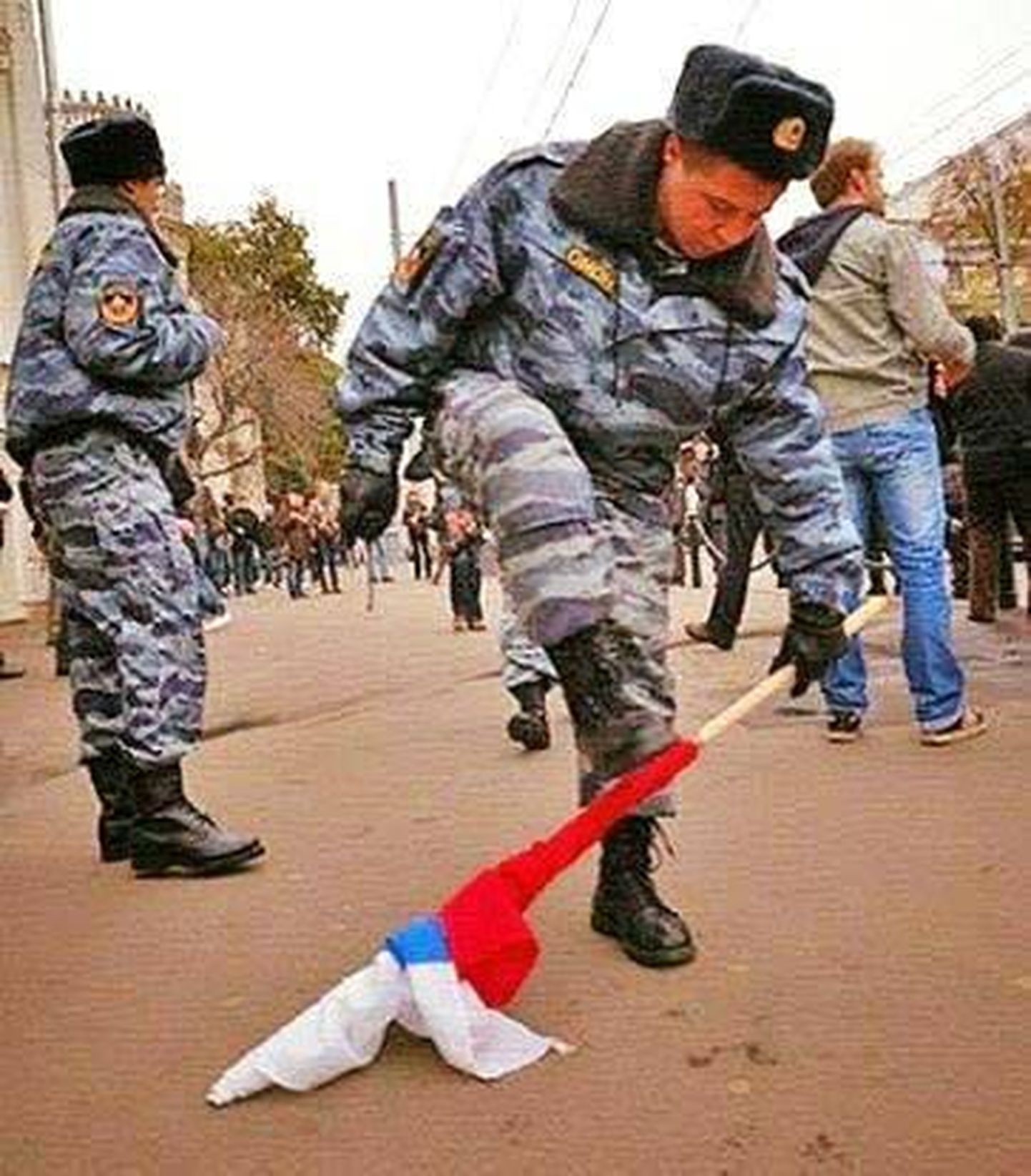 Vene politseinik pooleks murdmas protesteerijatelt ära võetud lippu.